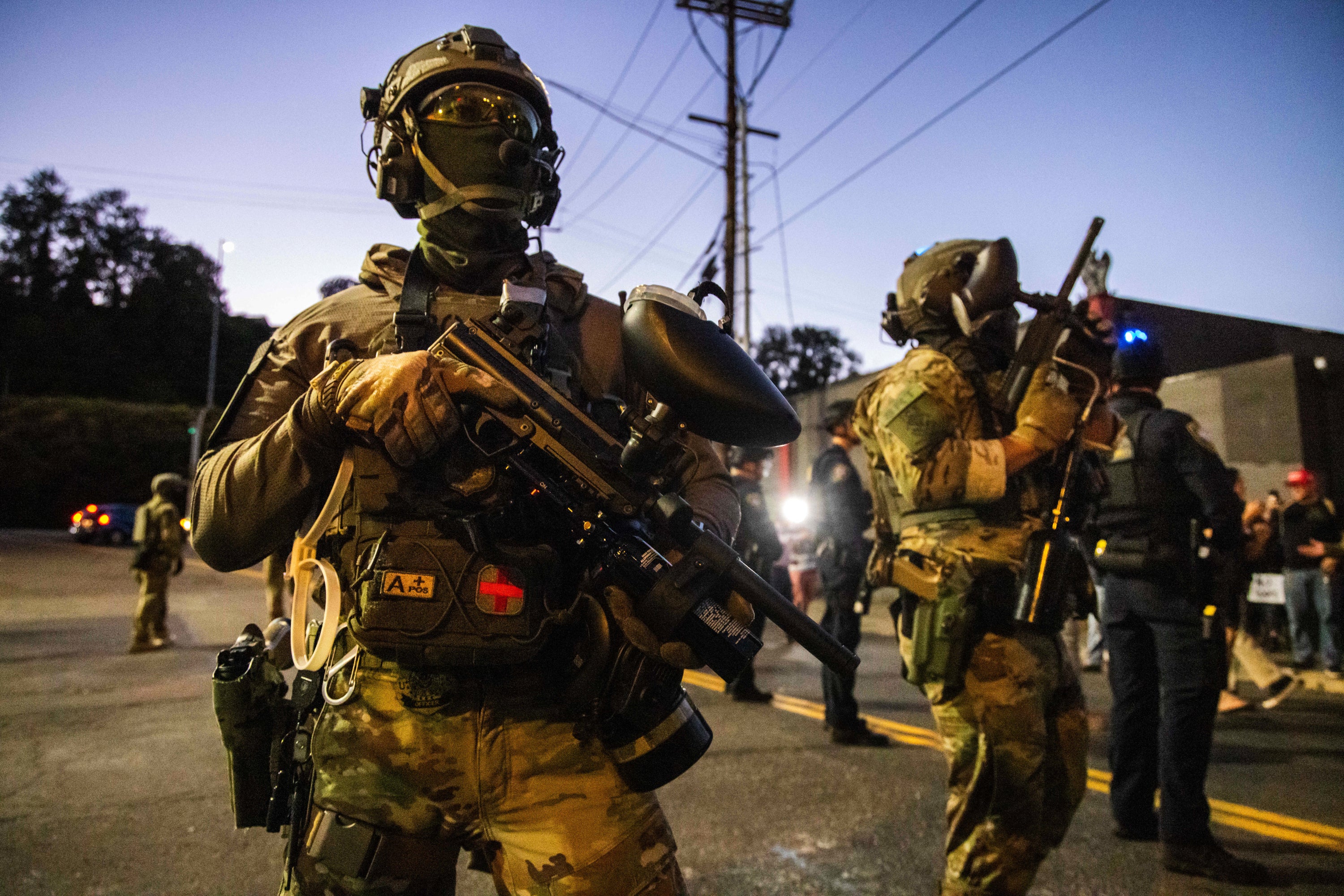 <p>Federal officers stand guard near an Immigration and Customs Enforcement facility in Portland, Oregon</p>