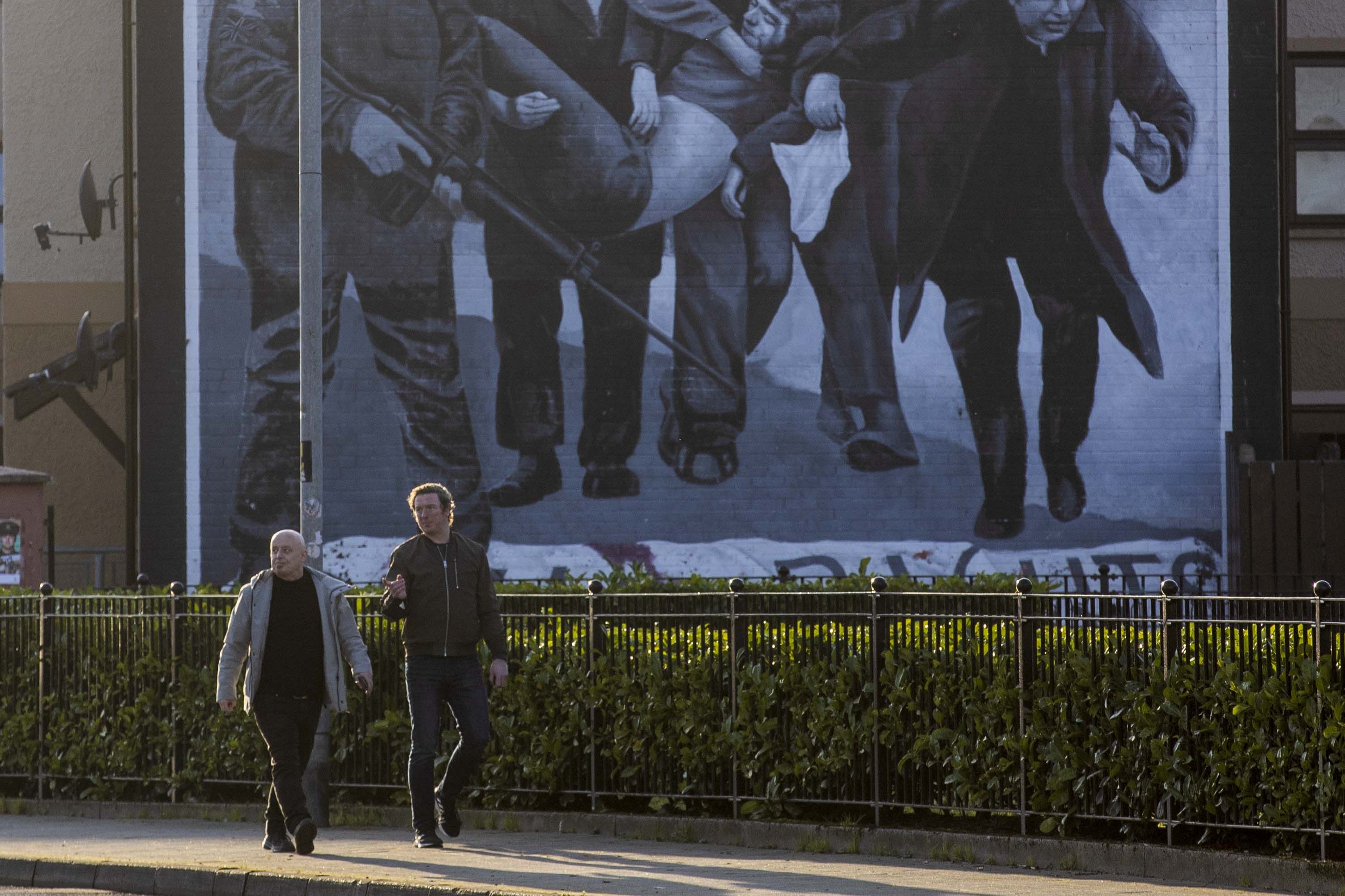 People walking past the Bloody Sunday Commemoration mural in Derry, Northern Ireland (Liam McBurney/PA)