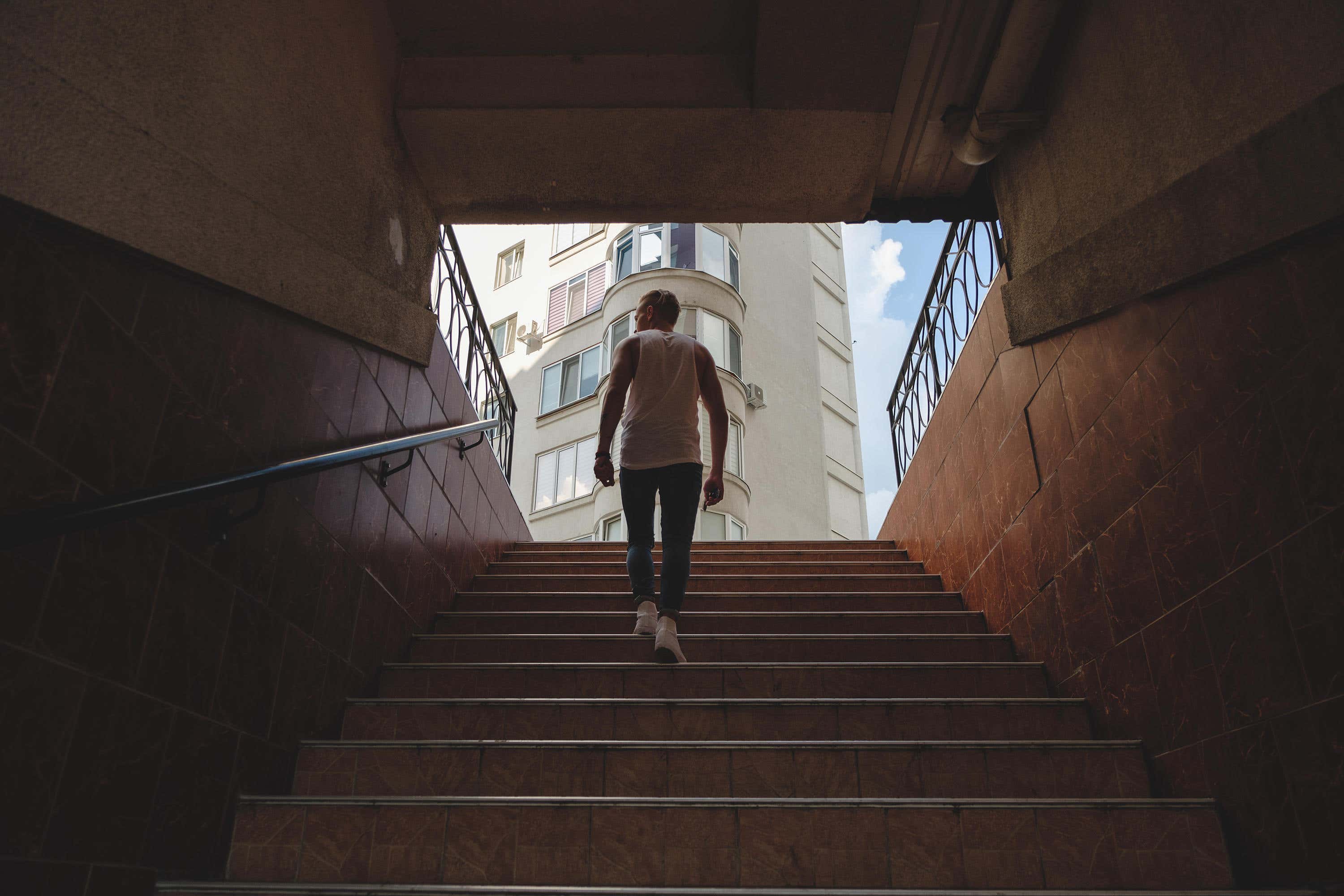 M56TYT Young man climbing stairs in pedestrian subway