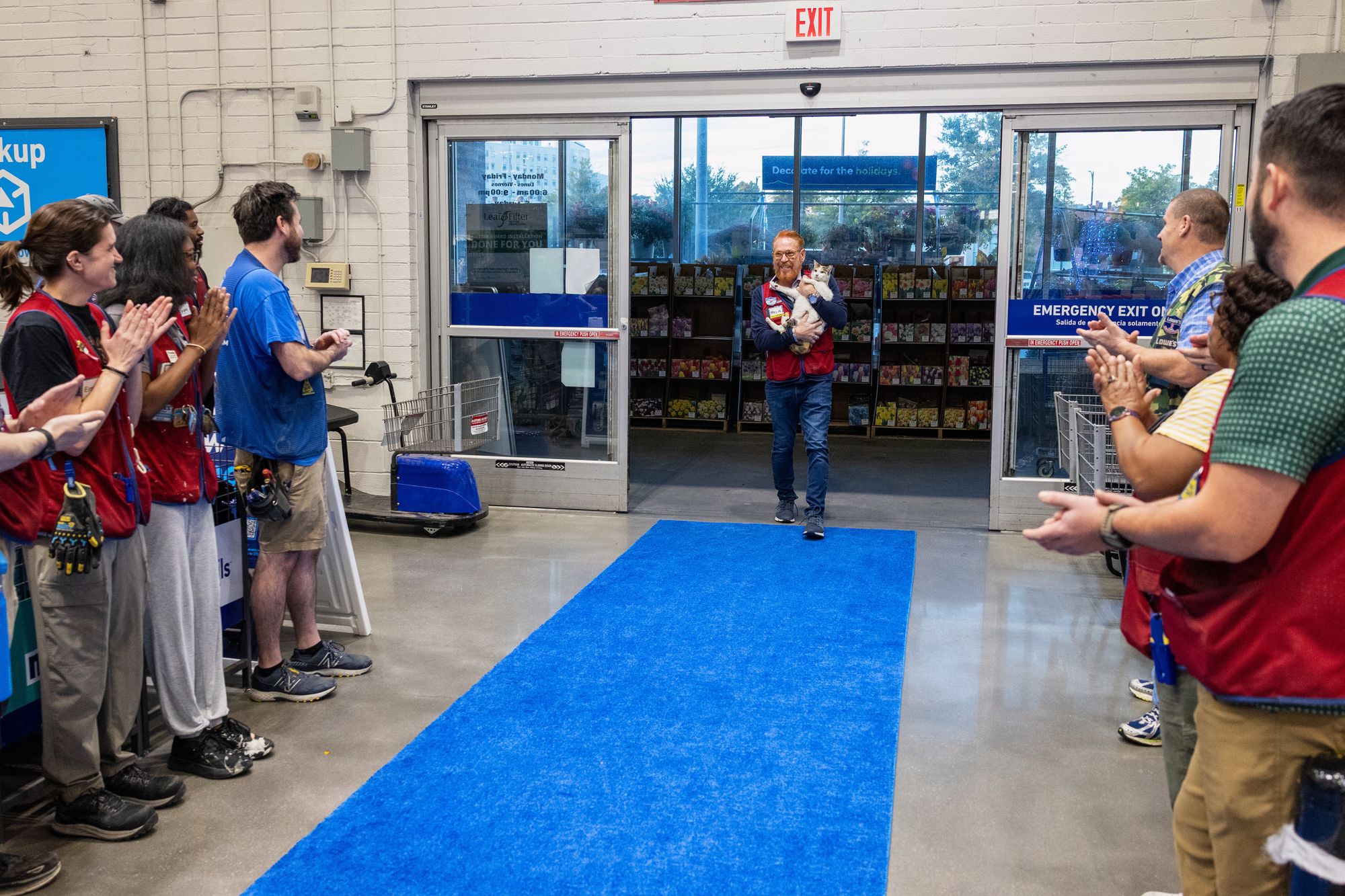 In this photo provided by Lowe's, employees welcome back Francine, the store cat, after she disappeared unexpectedly