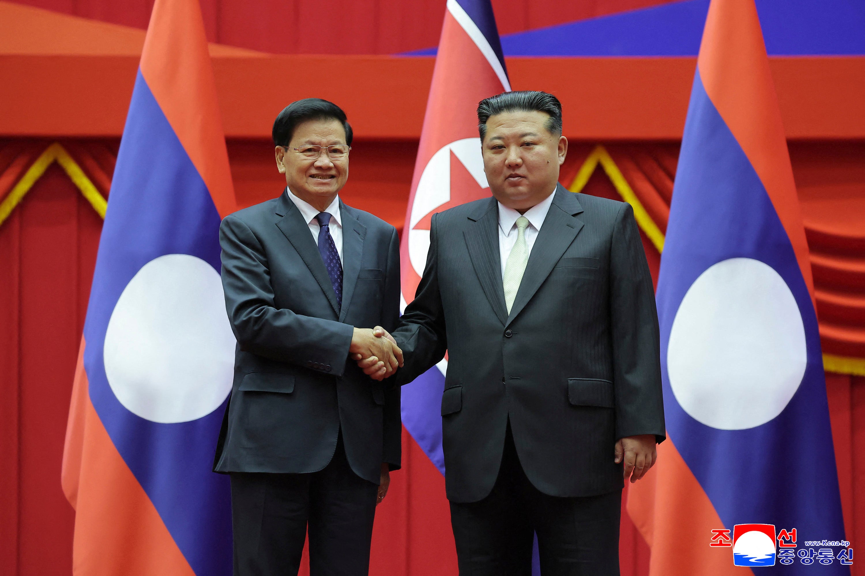 North Korean leader Kim Jong Un (R) and Laos' President Thongloun Sisoulith posing for photographs