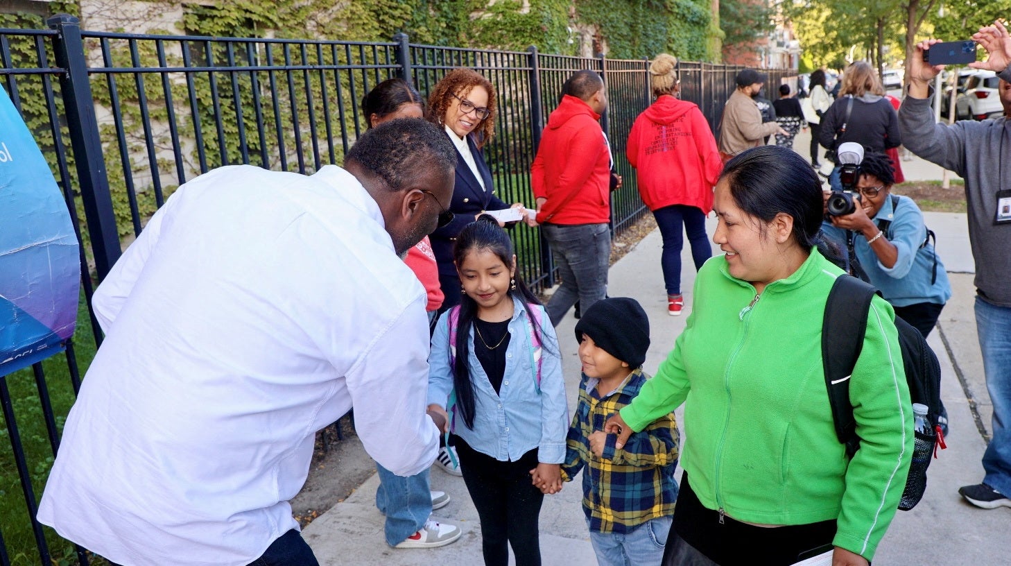 Chicago Mayor Brandon Johnson greets a student and her family outside Nash Elementary School