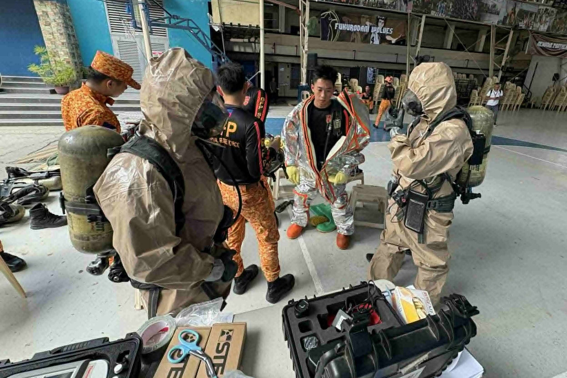 Firefighters wear protective suits as they respond to a chemical spill incident at the San Pedro College following a strong earthquake in Davao City, southern Philippines