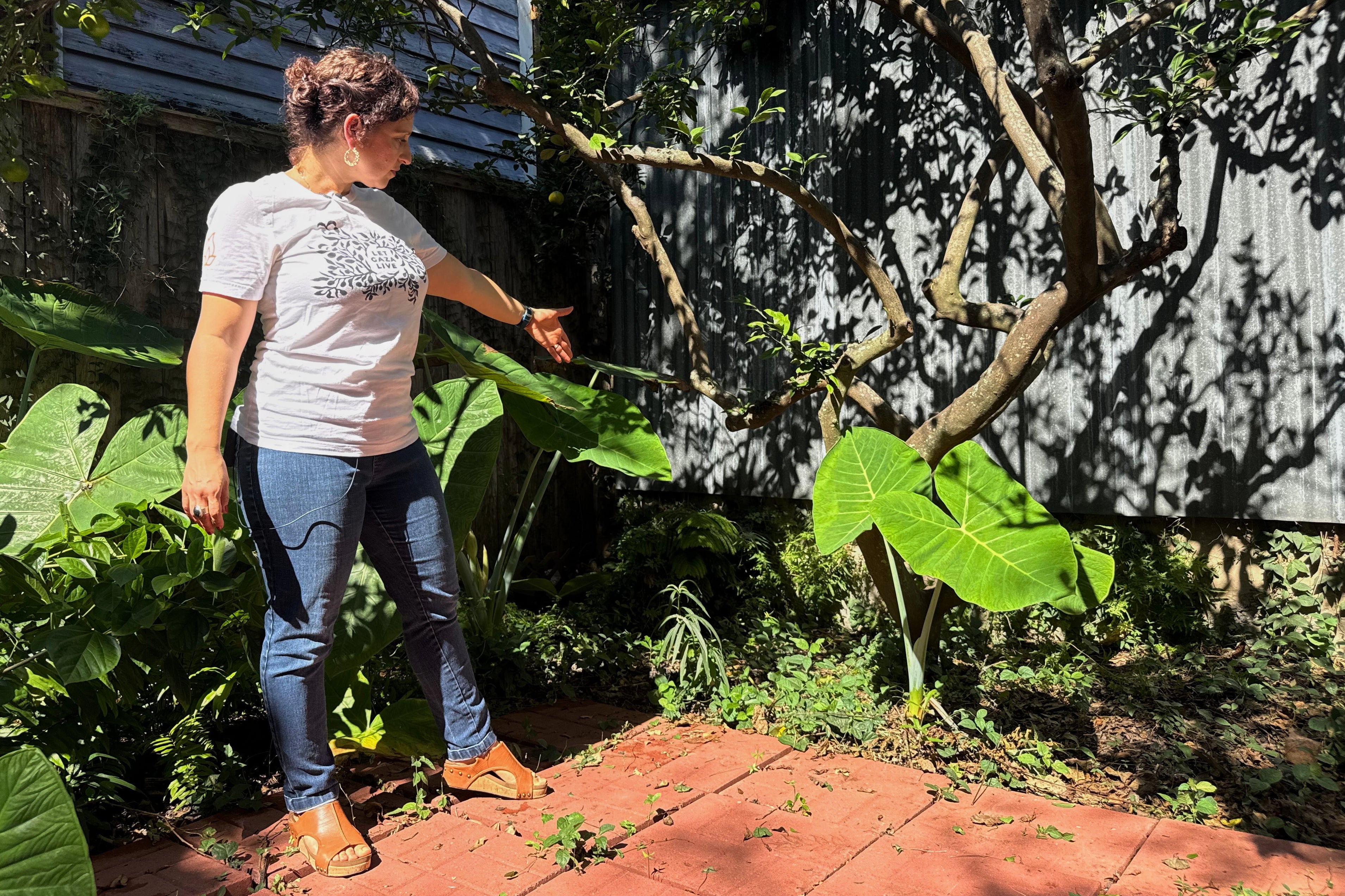 New Orleans resident Daniella Santoro points out the spot in her backyard where her family discovered a 1,900-year-old gravestone for a Roman sailor that had been missing for decades from an Italian museum, on Thursday, Oct. 9, 2025. (AP Photo/Jack Brook)