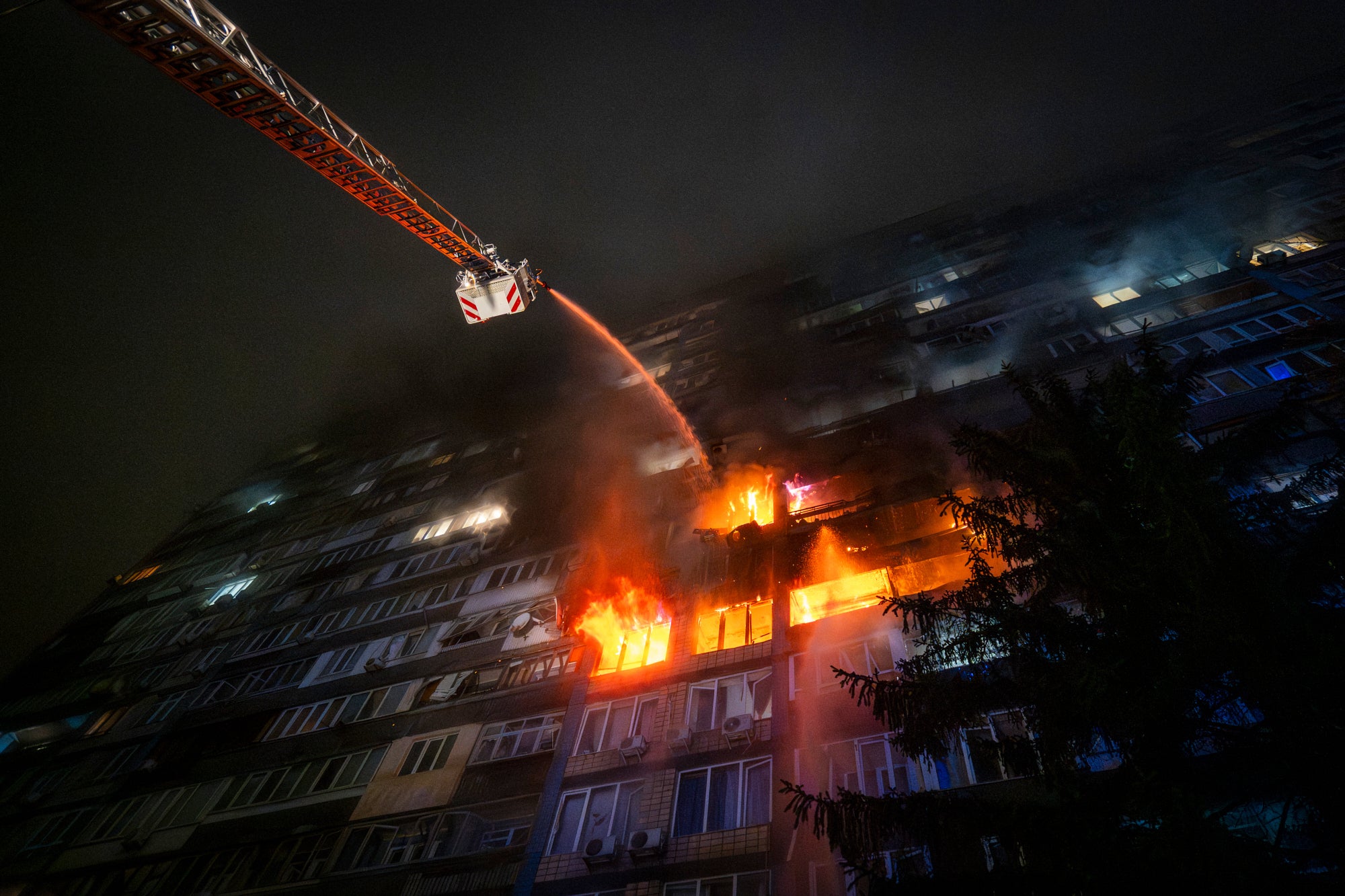 Emergency services personnel work to extinguish a fire following a Russian attack in Kyiv, Ukraine