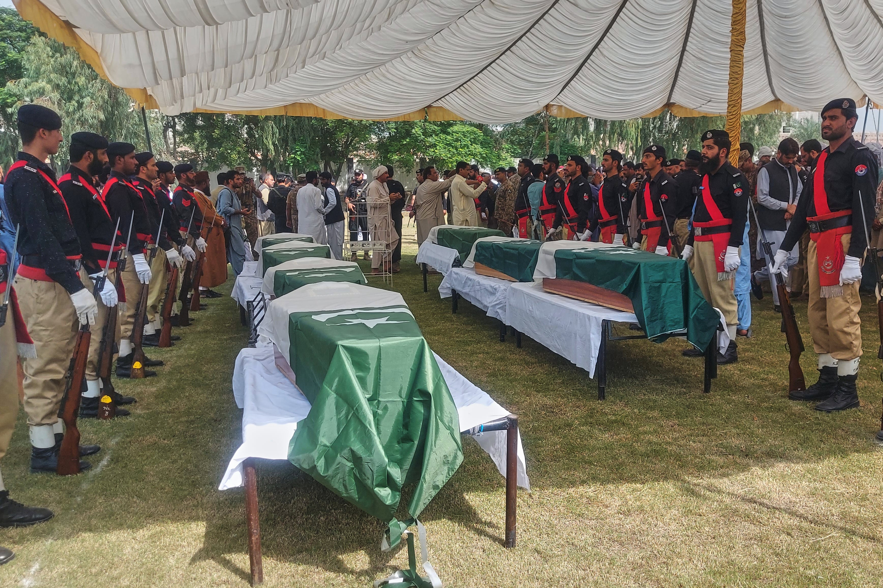 Officials and others attend funeral prayers of police officers, who were killed when gunmen attacked a police training center, in Dera Ismail Khan in northwestern Pakistan, Saturday