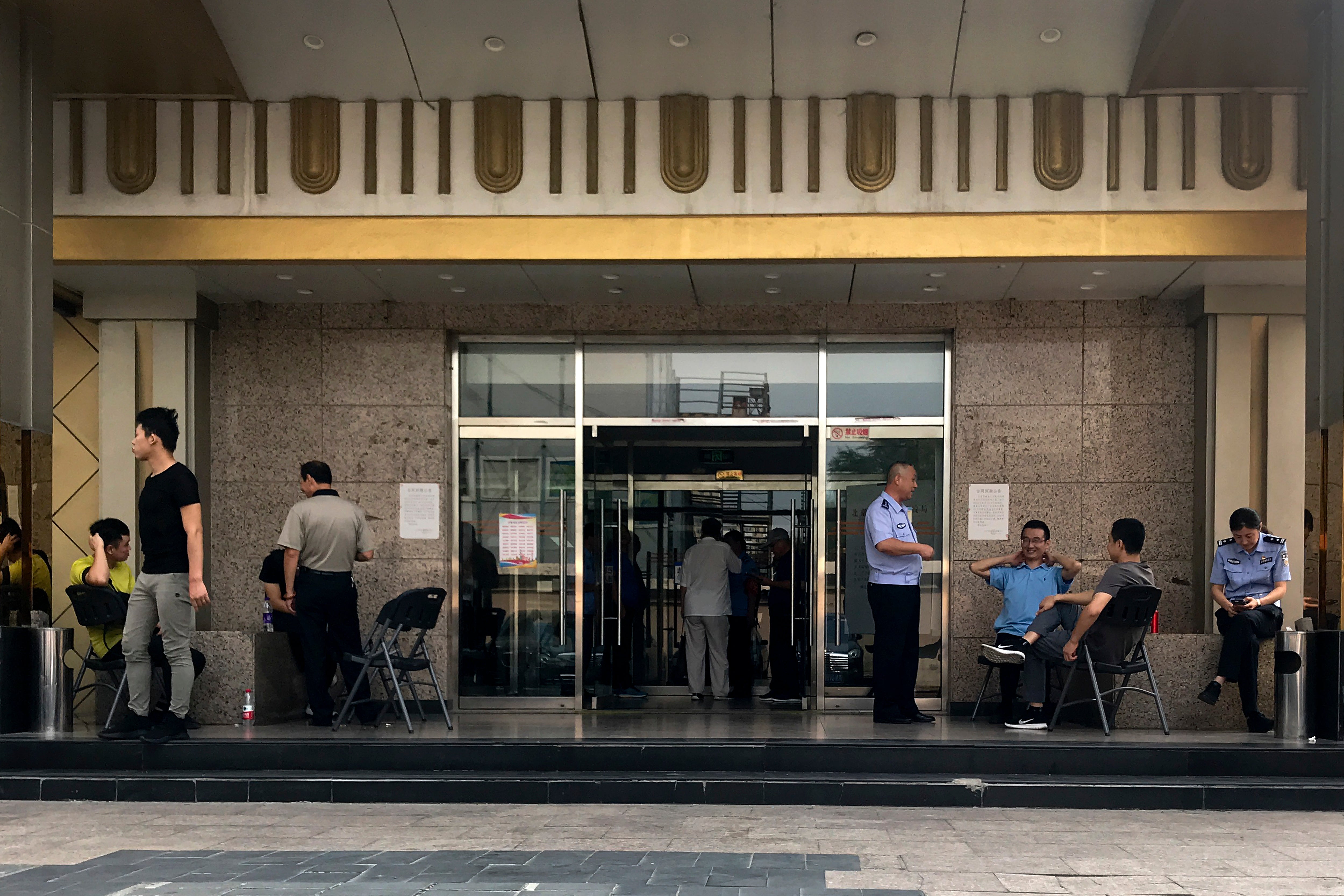 Police officers guard at the main entrance door to a building where Zion church is located after the church was shutdown by authorities in Beijing