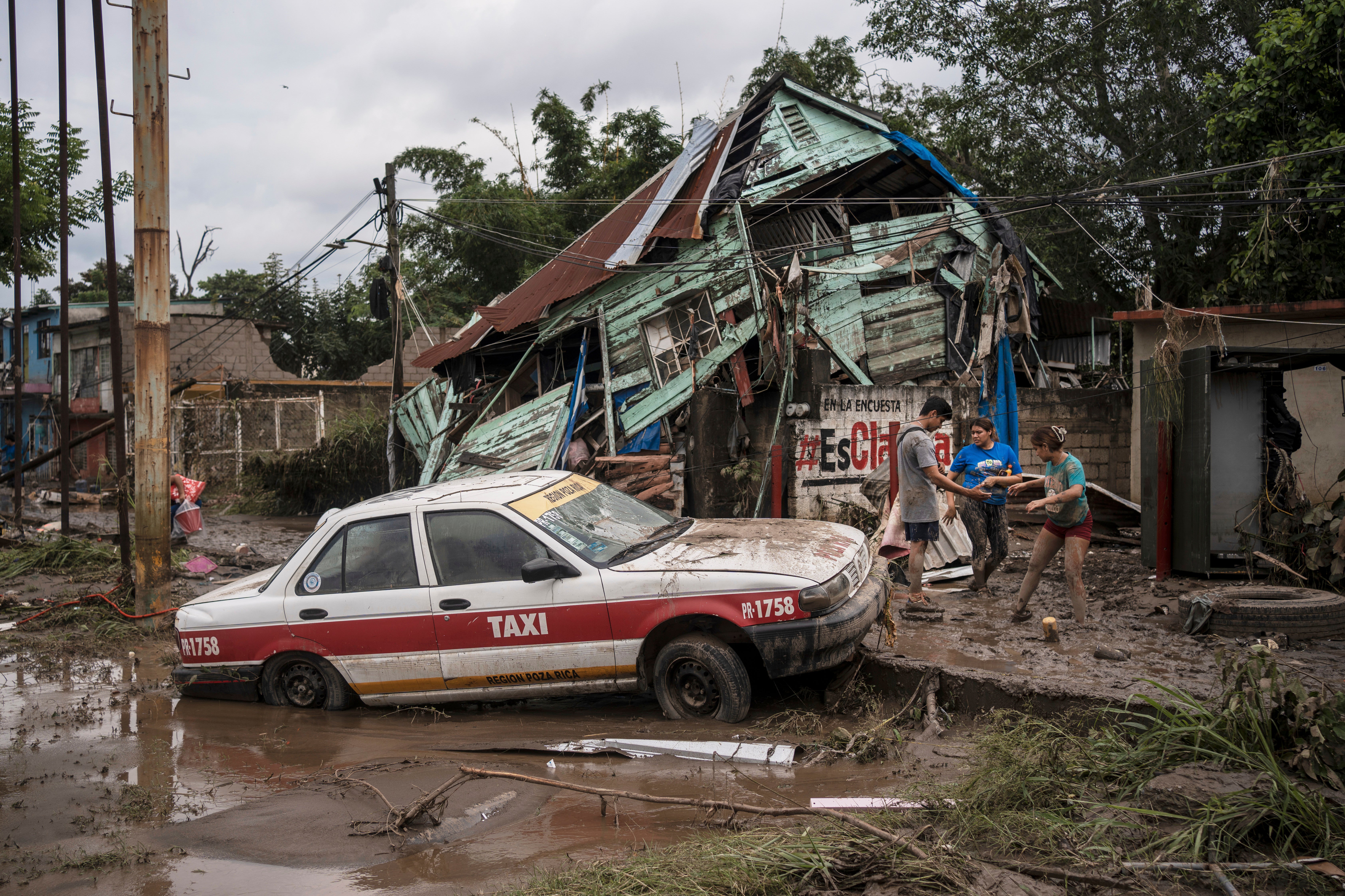 Neighbors gather around a damaged house after heavy rainfall in Poza Rica, Veracruz state, Mexico