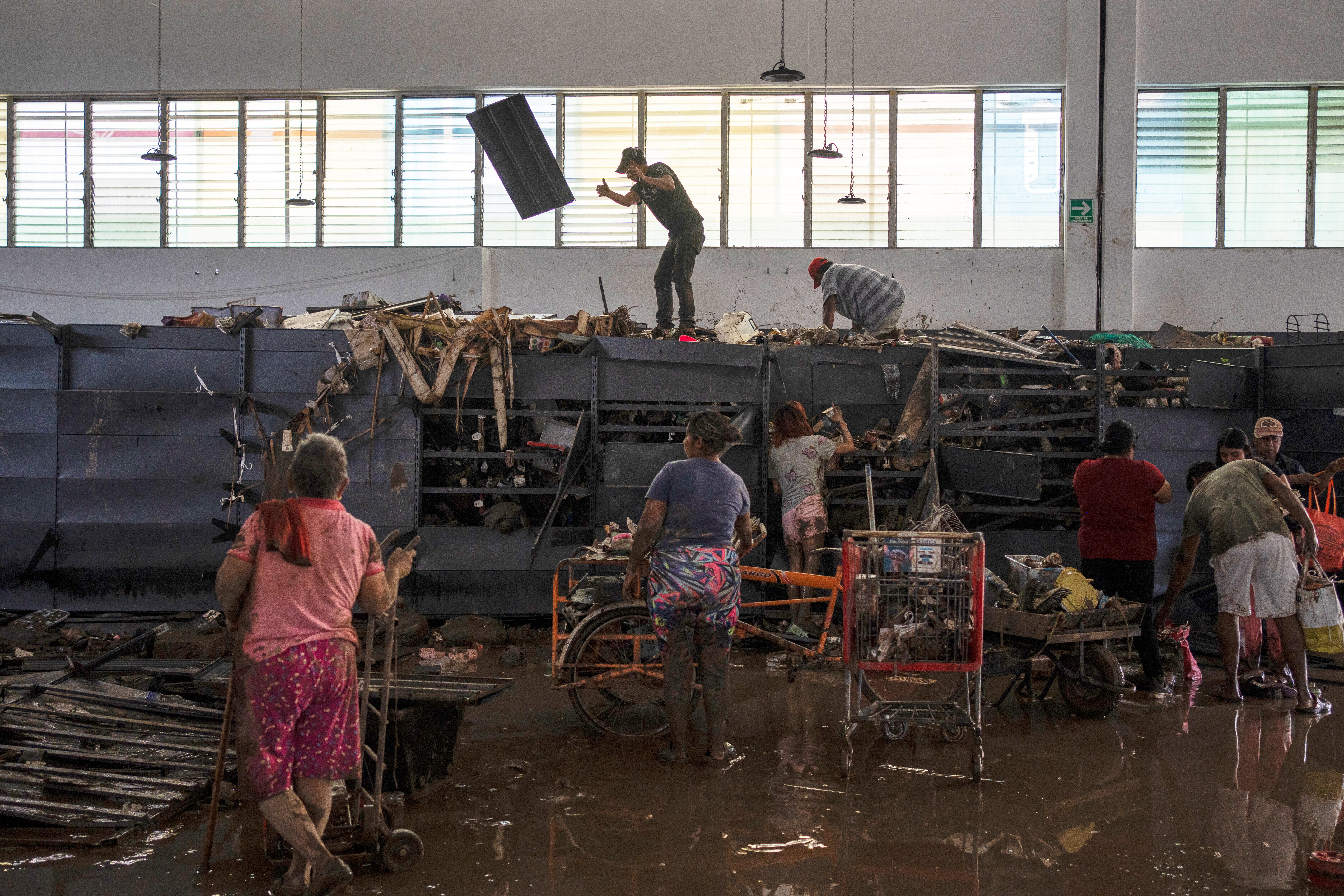 People loot a supermarket damaged by heavy rainfall in Poza Rica, Veracruz state, Mexico