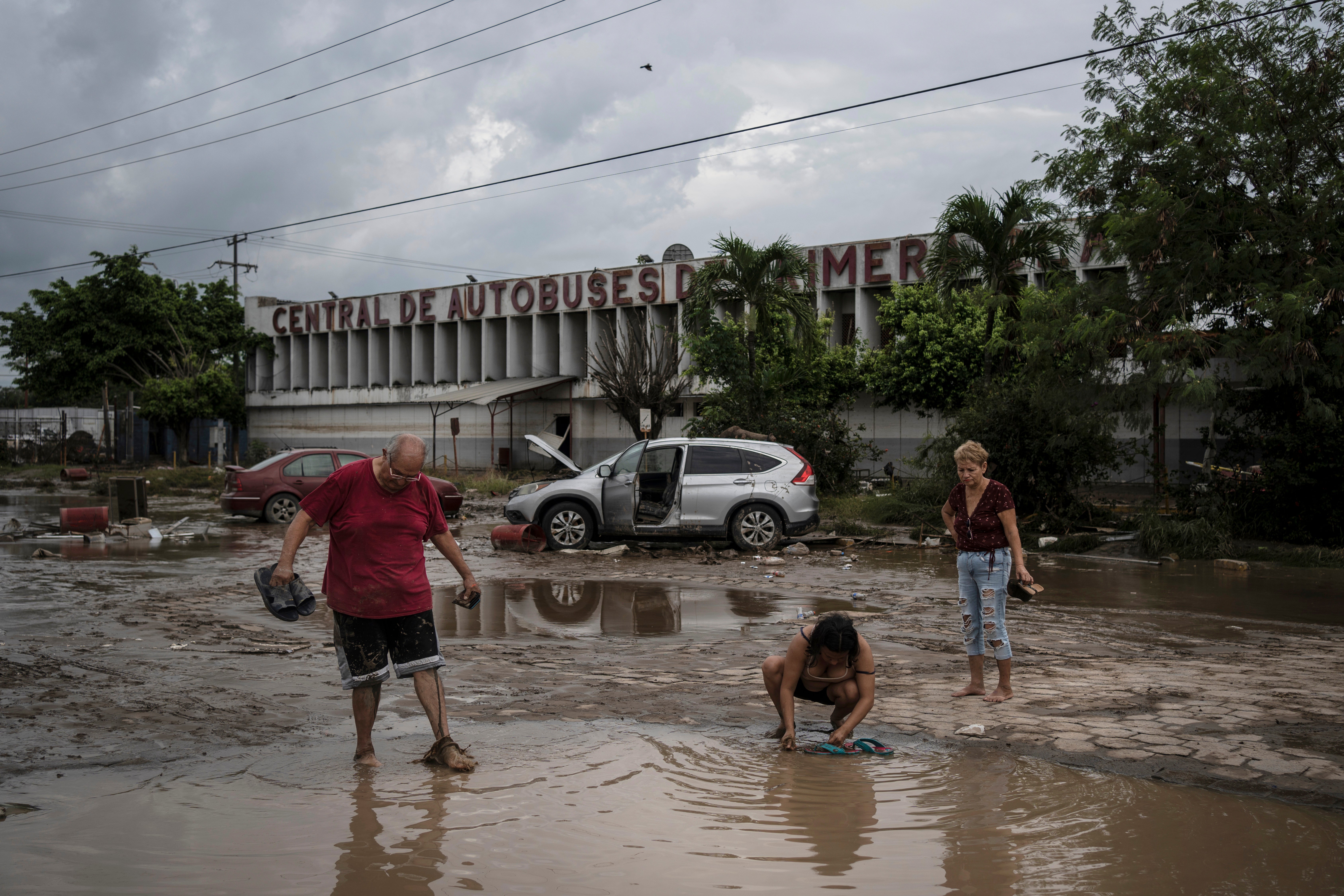 Residents walk past a damaged bus station after heavy rainfall in Poza Rica, Mexico, on 11 October 2025