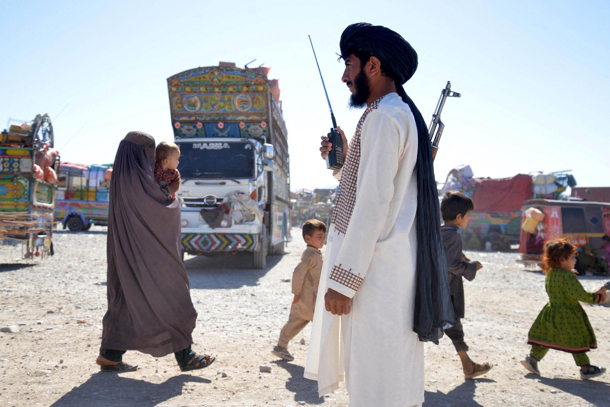 A Taliban security personnel stands guard as Afghans deported from Pakistan arrive at a registration centre at Takhta Pul in Kandahar province