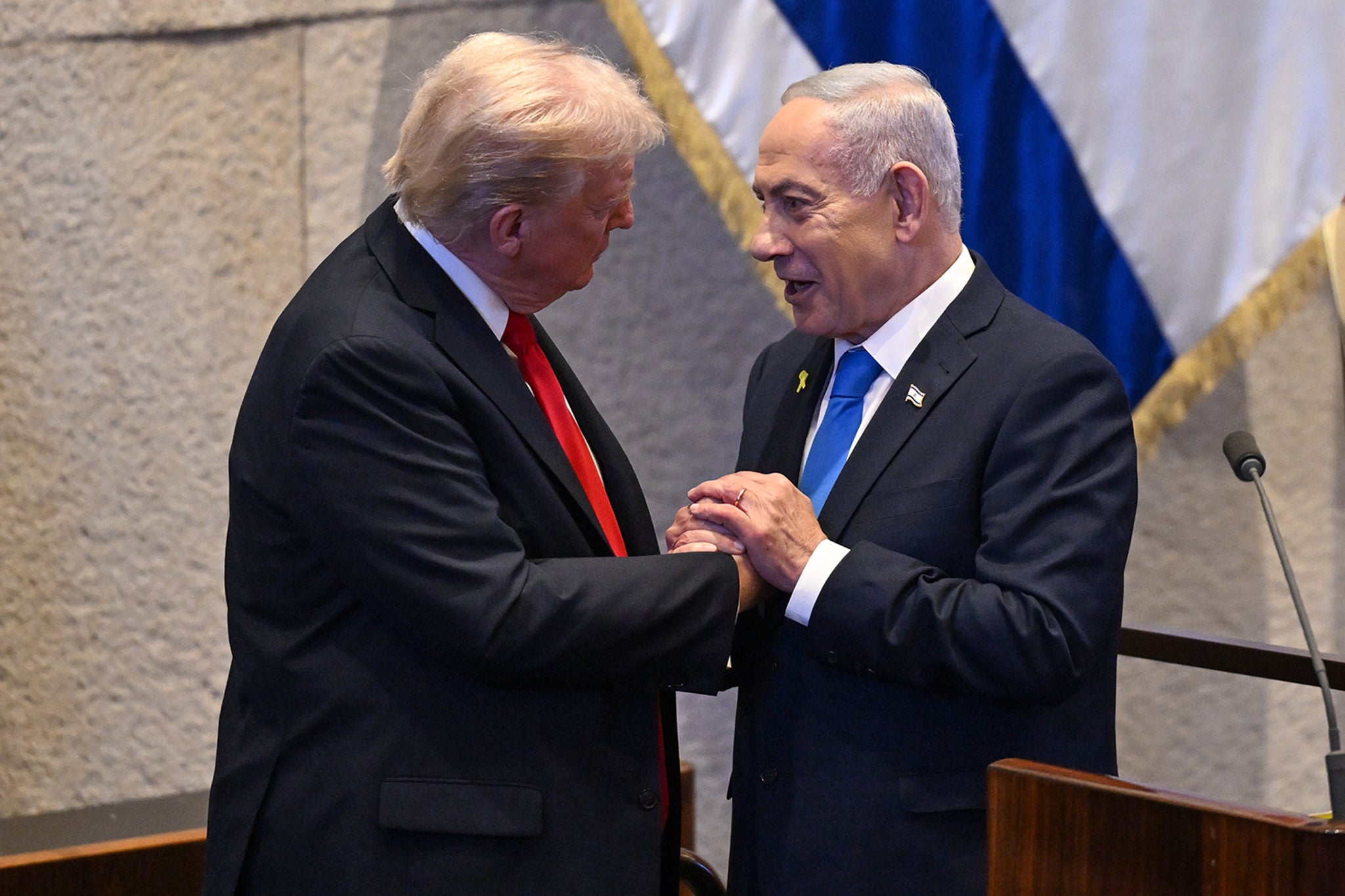 President Donald Trump clasps hands with Israeli Prime Minister Benjamin Netanyahu in the Knesset