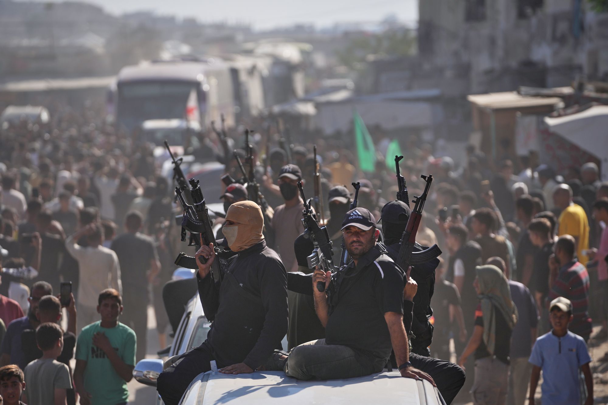 Hamas gunmen on pickup trucks escort buses carrying freed Palestinian prisoners and detainees on 13 October
