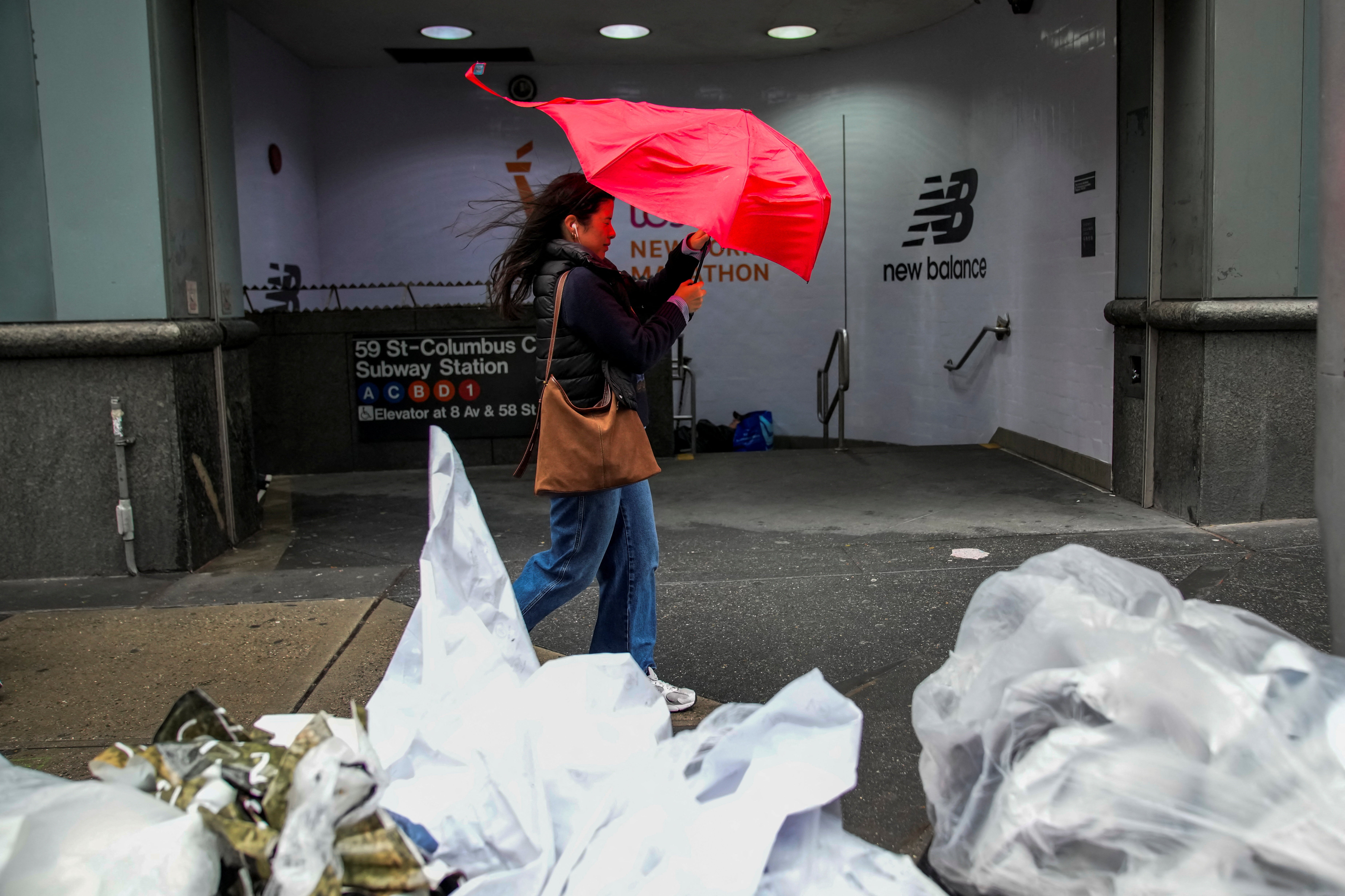 A person struggles with her umbrella as she walks through wind and rain during a nor'easter storm in New York City, U.S.,