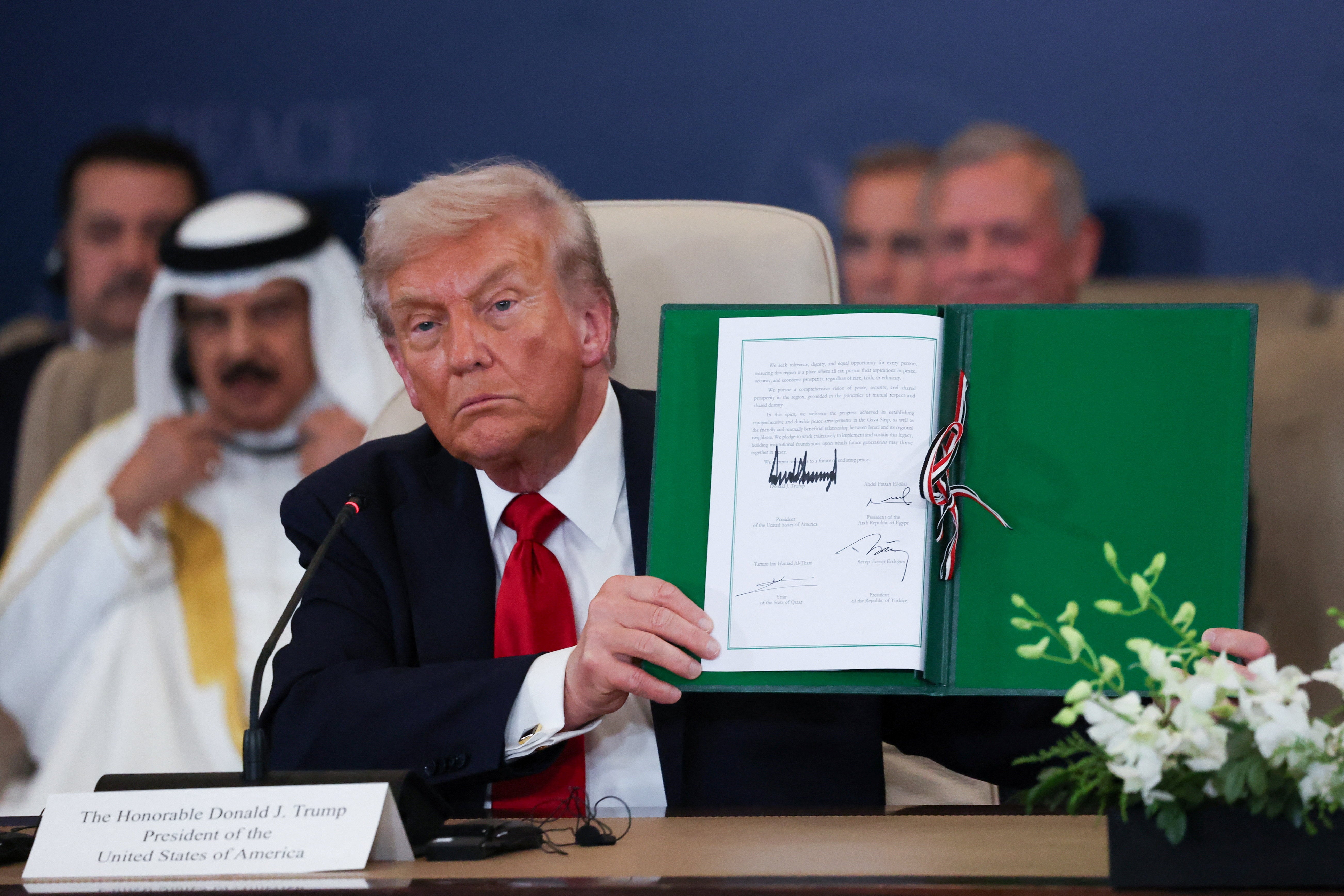 Donald Trump poses with the signed agreement during the Sharm El Sheikh peace summit (Suzanne Plunkett/PA)