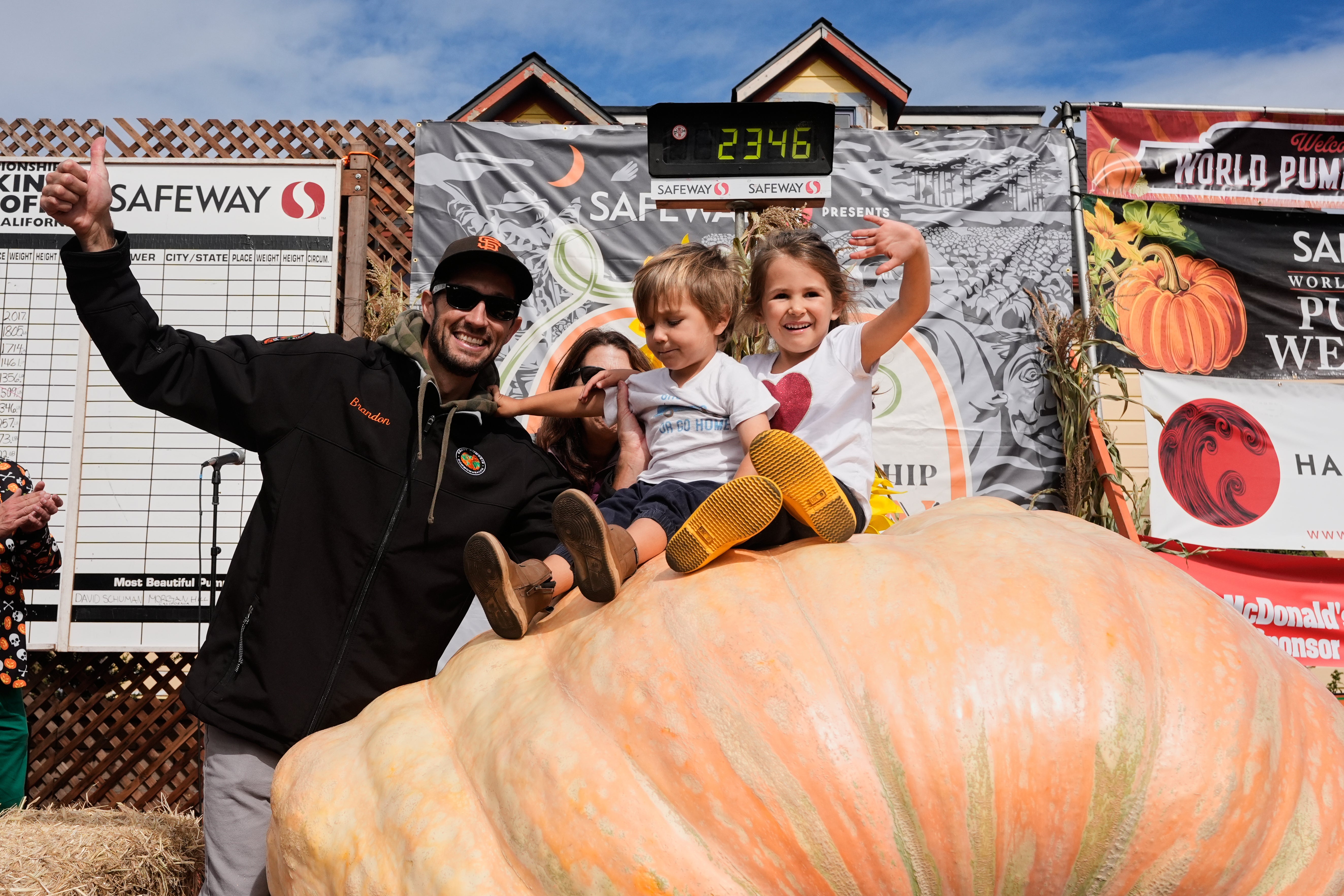 From left, Brandon Dawson celebrates with his children Roman and Ayla after winning the Safeway 52nd annual World Championship Pumpkin Weigh-Off