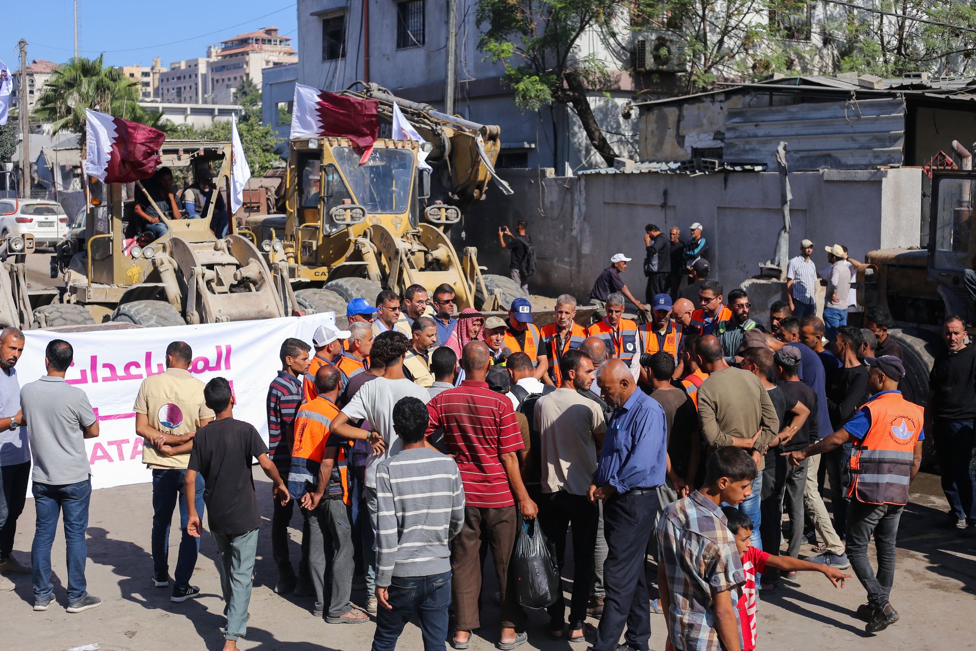 Gaza Municipality staff gather before deploying bulldozers to clear building rubble from main streets in Gaza City
