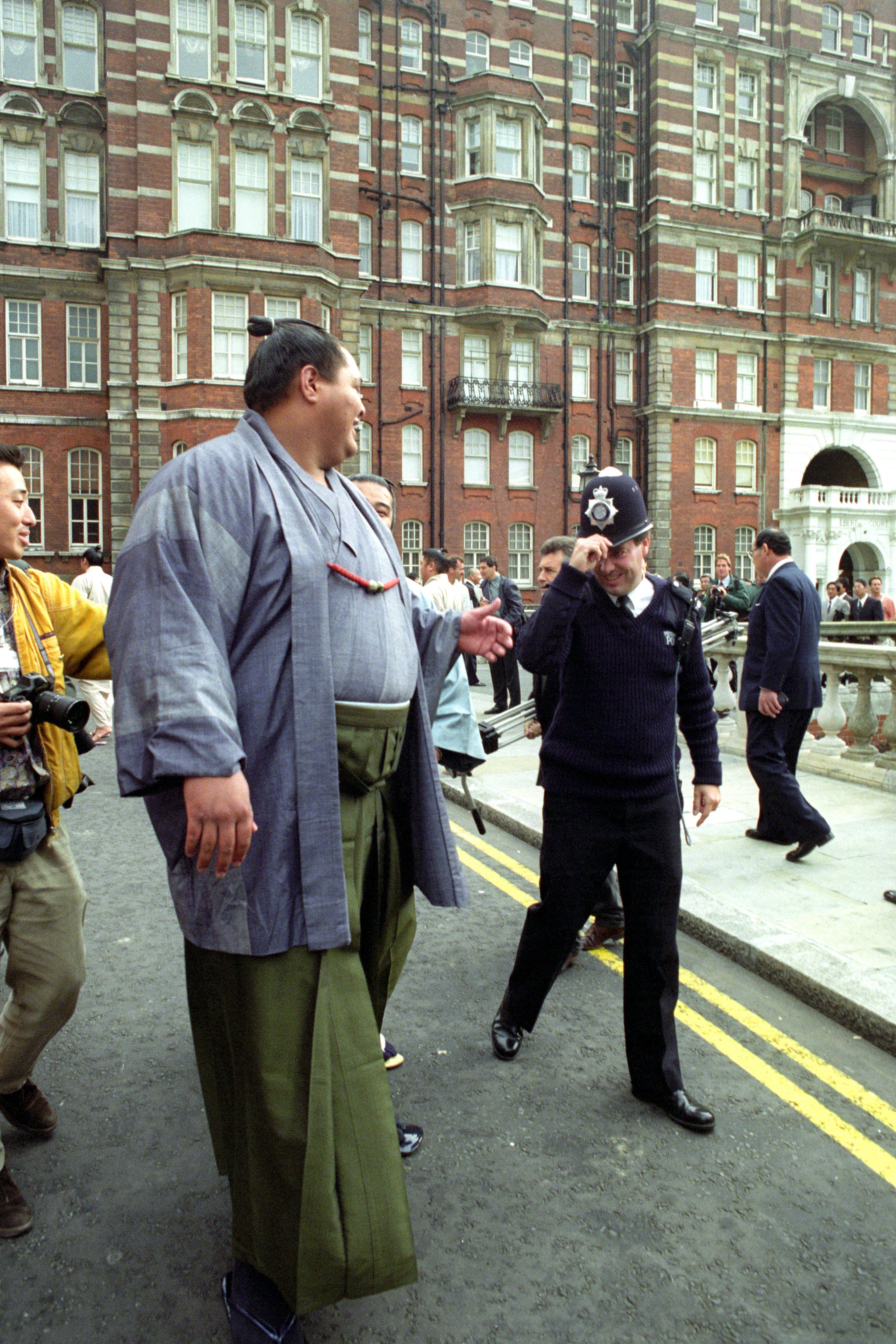 A policeman doffs his hat to one of the 40 top-ranked sumo wrestlers ahead of the 1991 event