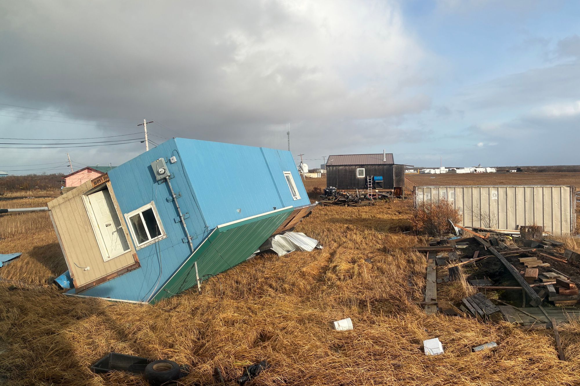 An unoccupied home rests on its roof after being knocked over in Kotlik
