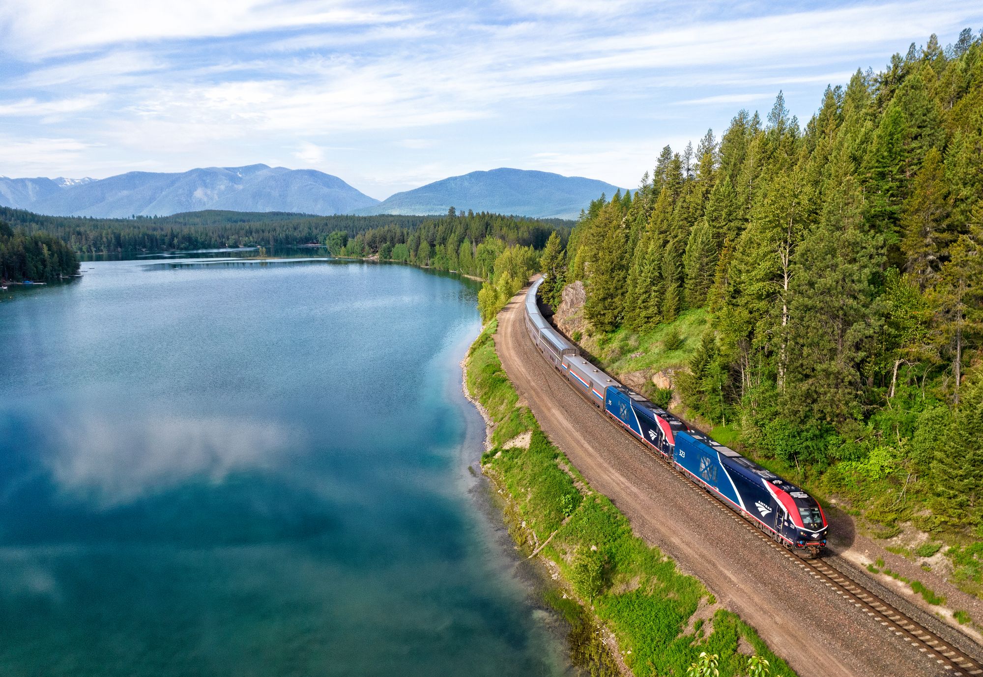 Amtrak's Empire Builder rolls along the shores of Lake Five near Coram, Montana