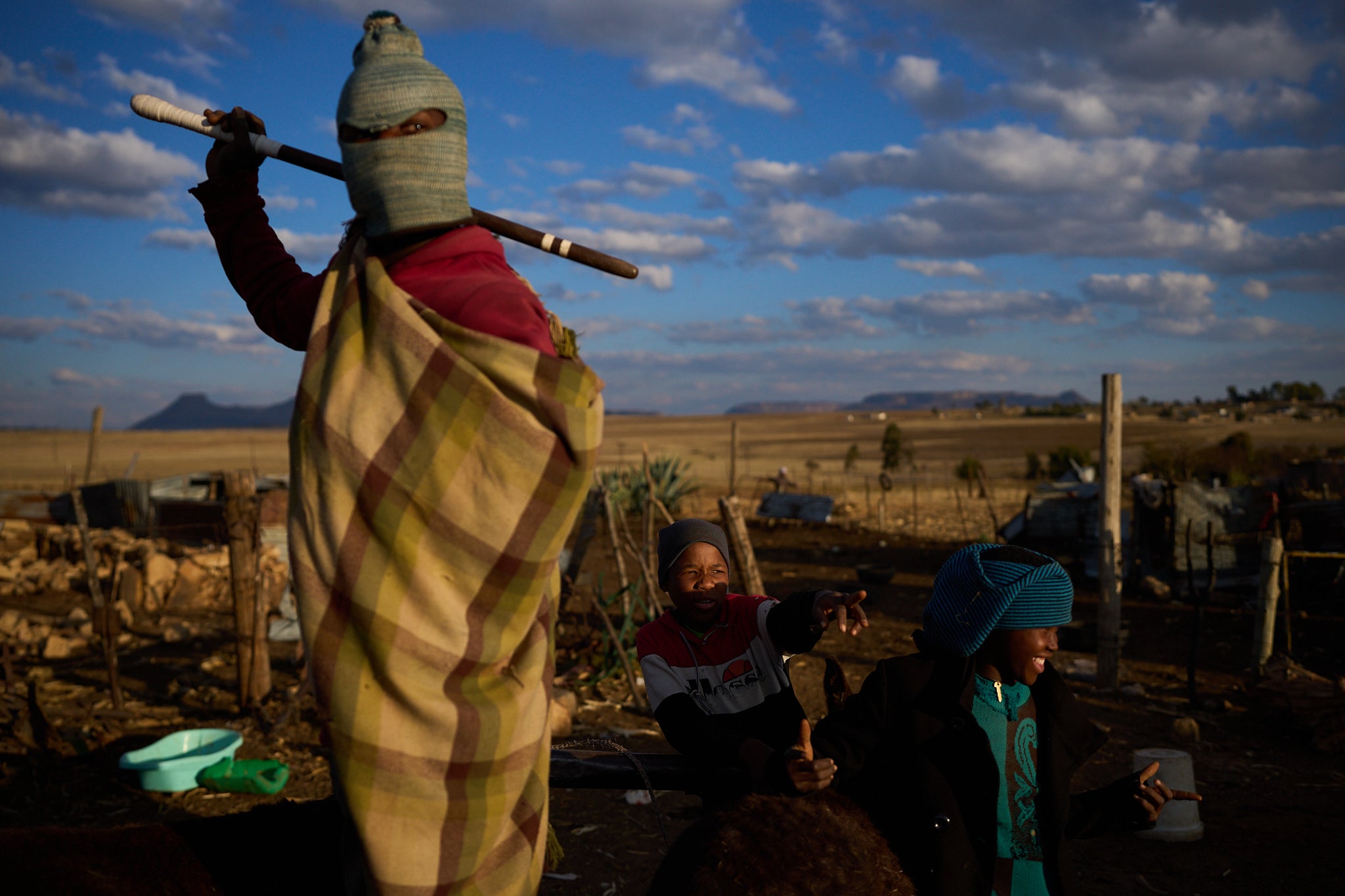 Boys stand outside their homes after a day of work in Mafeteng, Lesotho, July 12, 2025. (AP Photo/Bram Janssen)