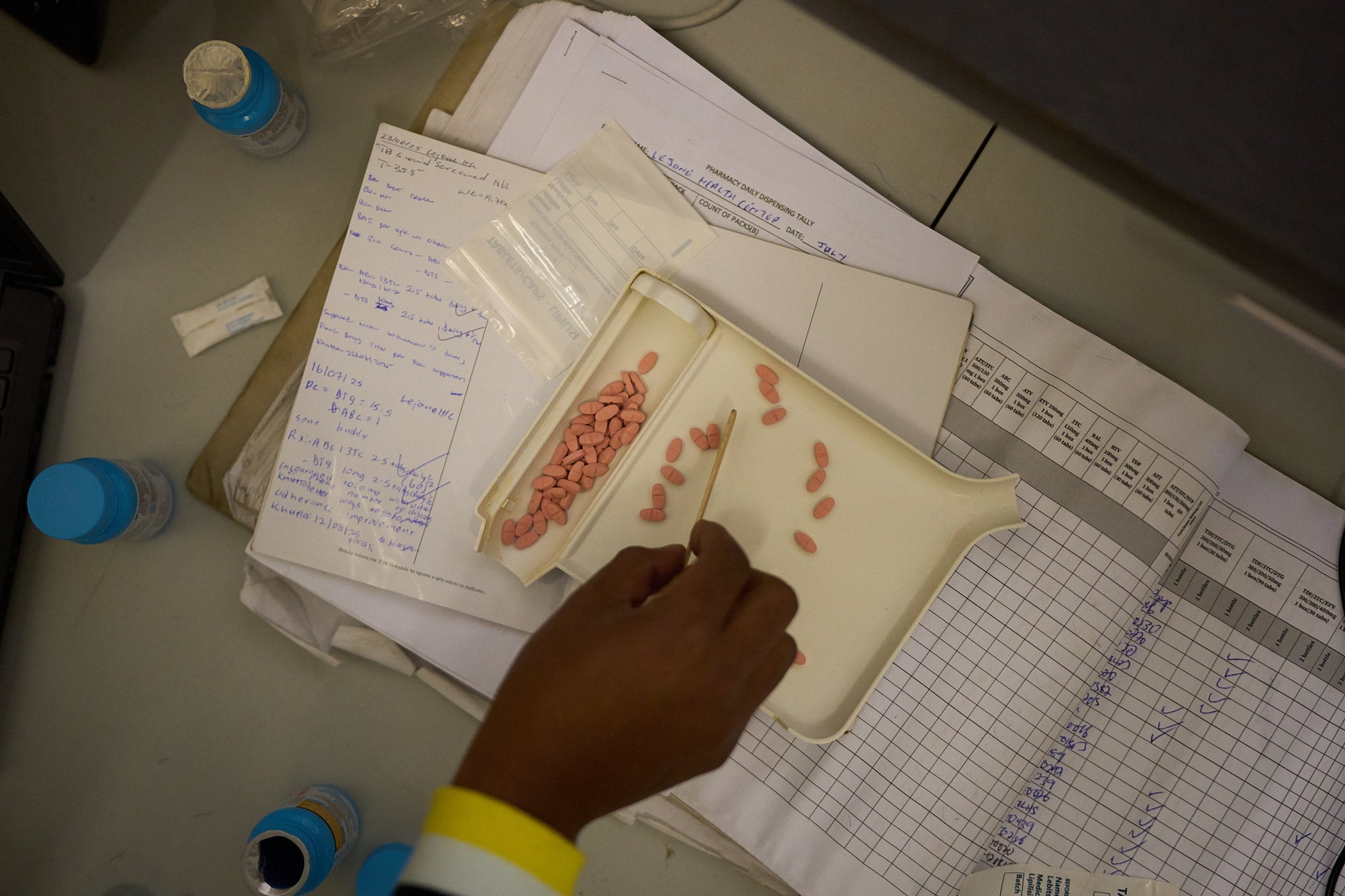 A pharmacist counts HIV medicine inside a clinic in Ha Lejone, Lesotho, July 16, 2025. (AP Photo/Bram Janssen)