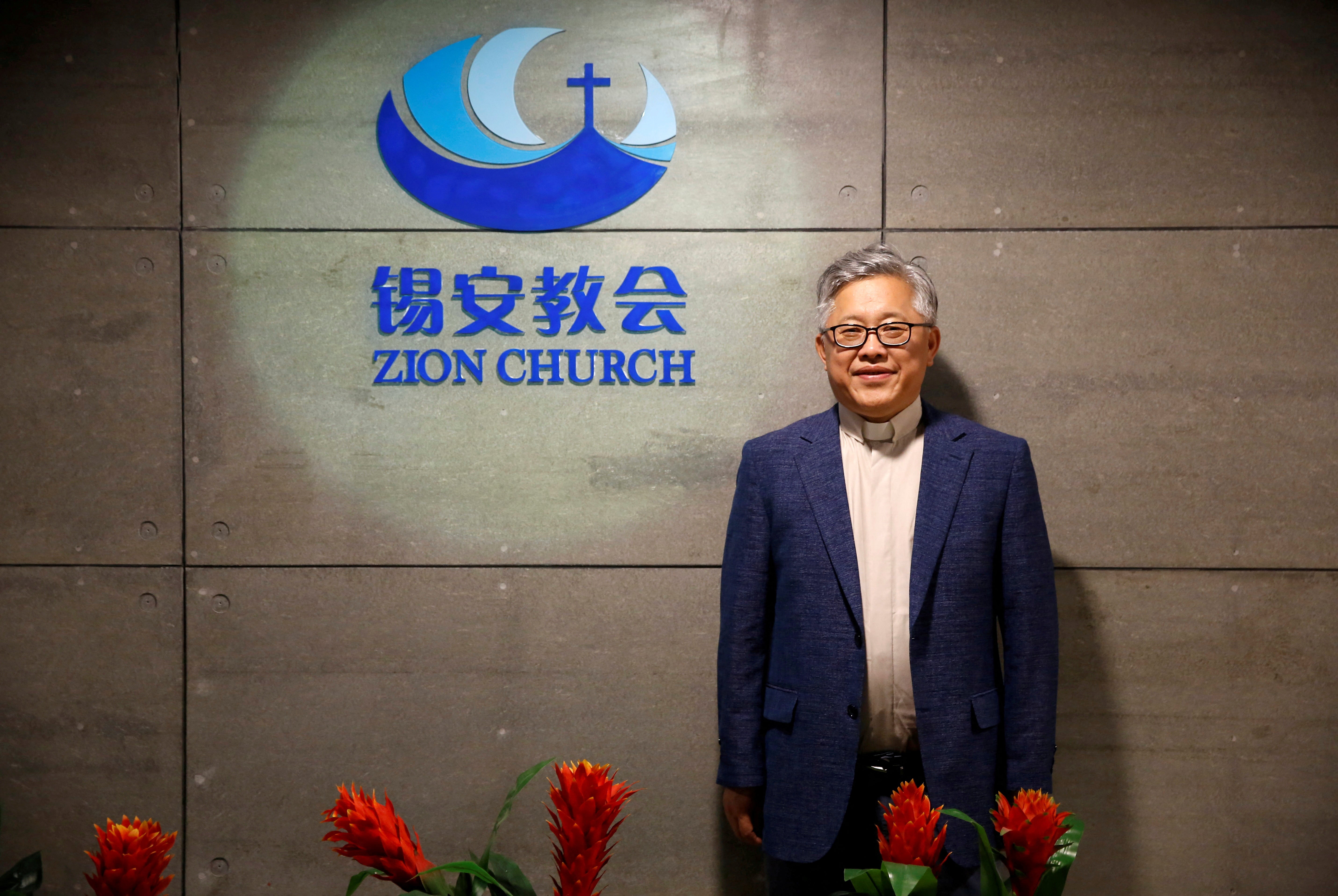 File: The head pastor of the Zion church in Beijing Jin Mingri poses for picures in the lobby of the unofficial Protestant "house" church in Beijing, China