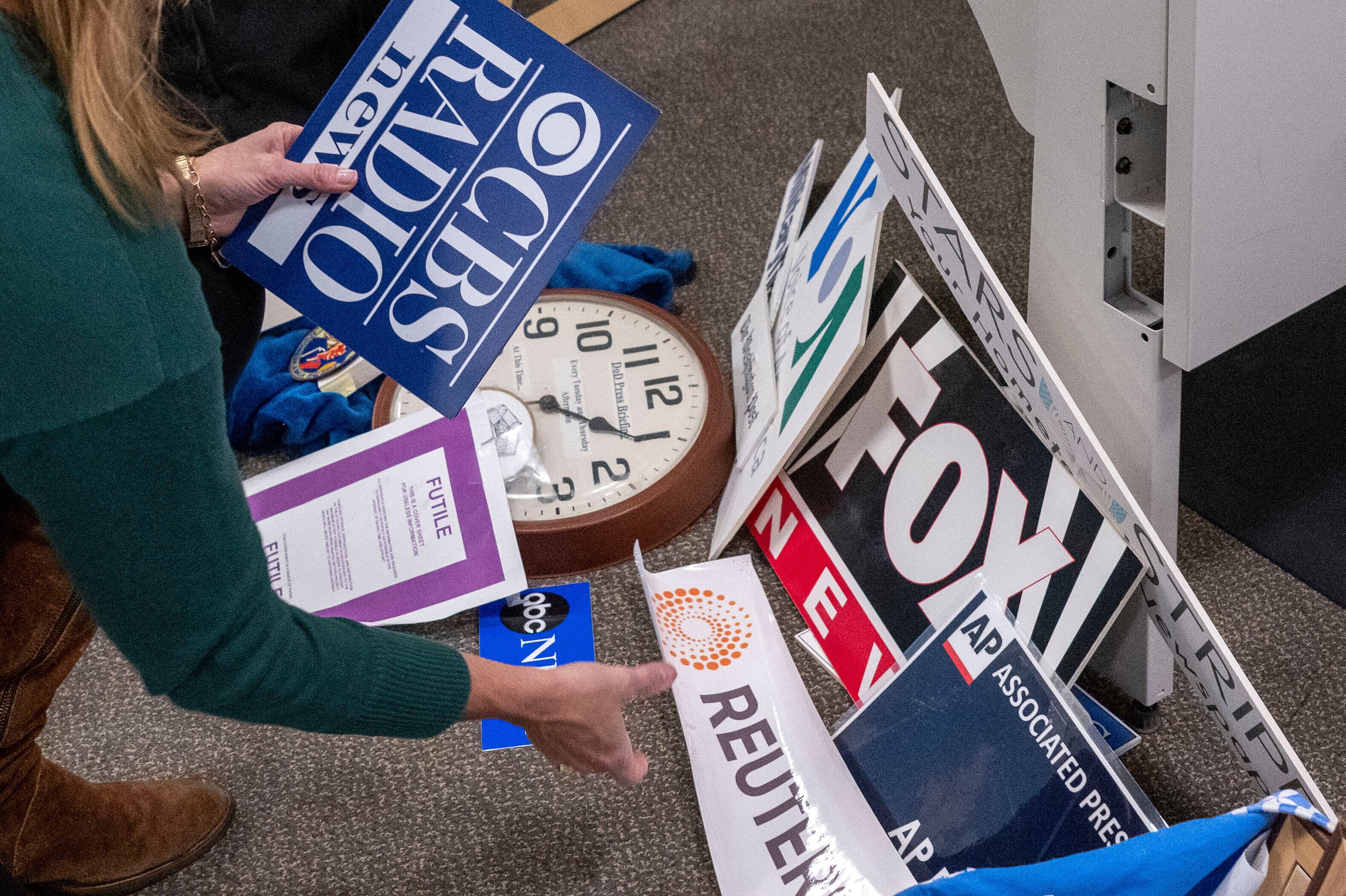 Washington Post reporter Tara Copp saves the name plaques from various news organizations as she and members of the media pack up their belongings in the press area in the Pentagon, Wednesday, Oct. 15, 2025