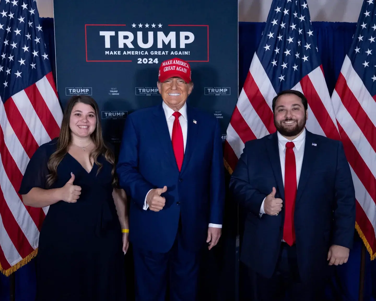 The photo from a 2024 campaign rally shows Trump giving his signature thumbs-up alongside Anne KayKaty (right) and Peter Giunta (left)