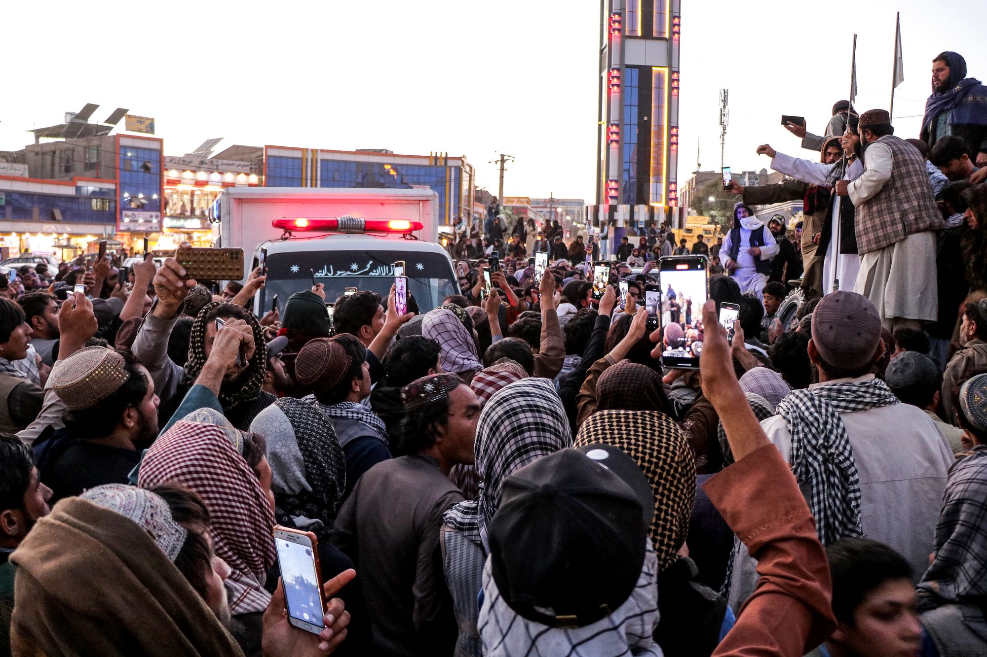 Afghan mourners and relatives gather around an ambulance carrying the coffin of late Abdul Ghafoor Abid, a local reporter for the broadcasting organisation National Radio Television of Afghanistan (RTA), during his funeral and burial ceremony at a village in the Ahmad Aba district of Paktia province on 15 October 2025