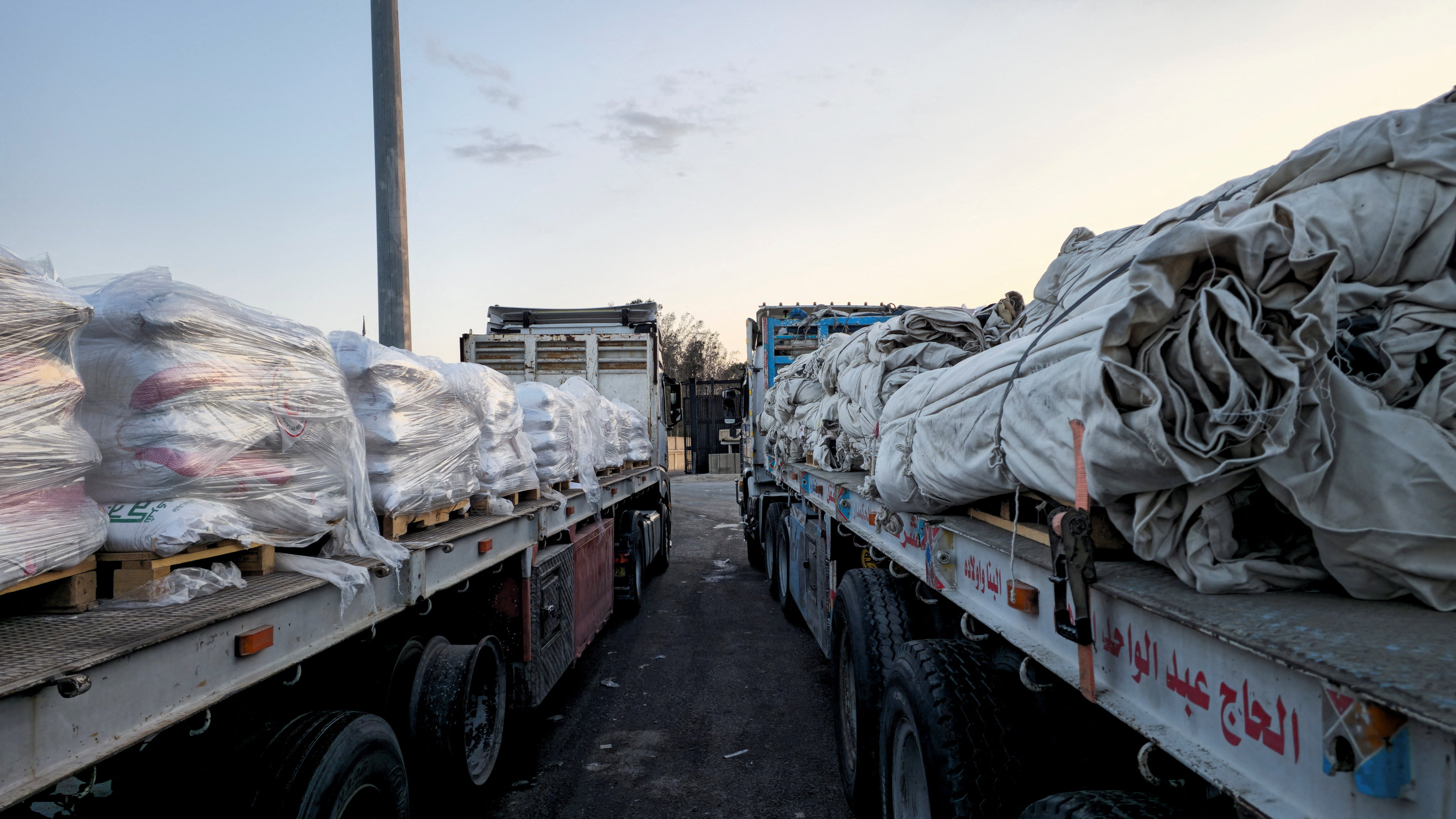 Trucks carrying humanitarian aid line up at the crossing into the Gaza Strip at the Rafah border on the Egypt side