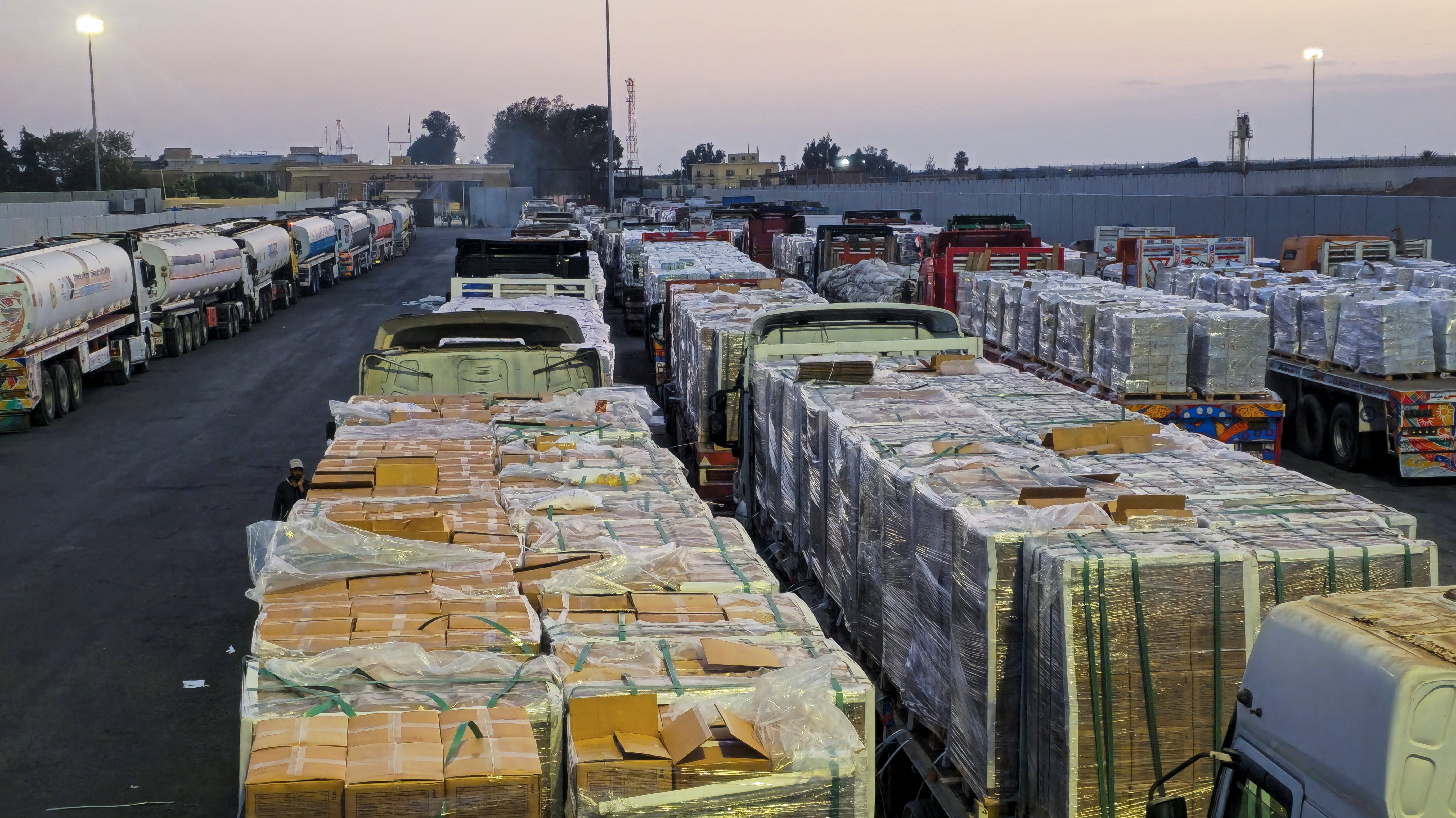 Trucks carrying humanitarian aid and fuel line up at the crossing into the Gaza Strip at the Rafah border on the Egypt side