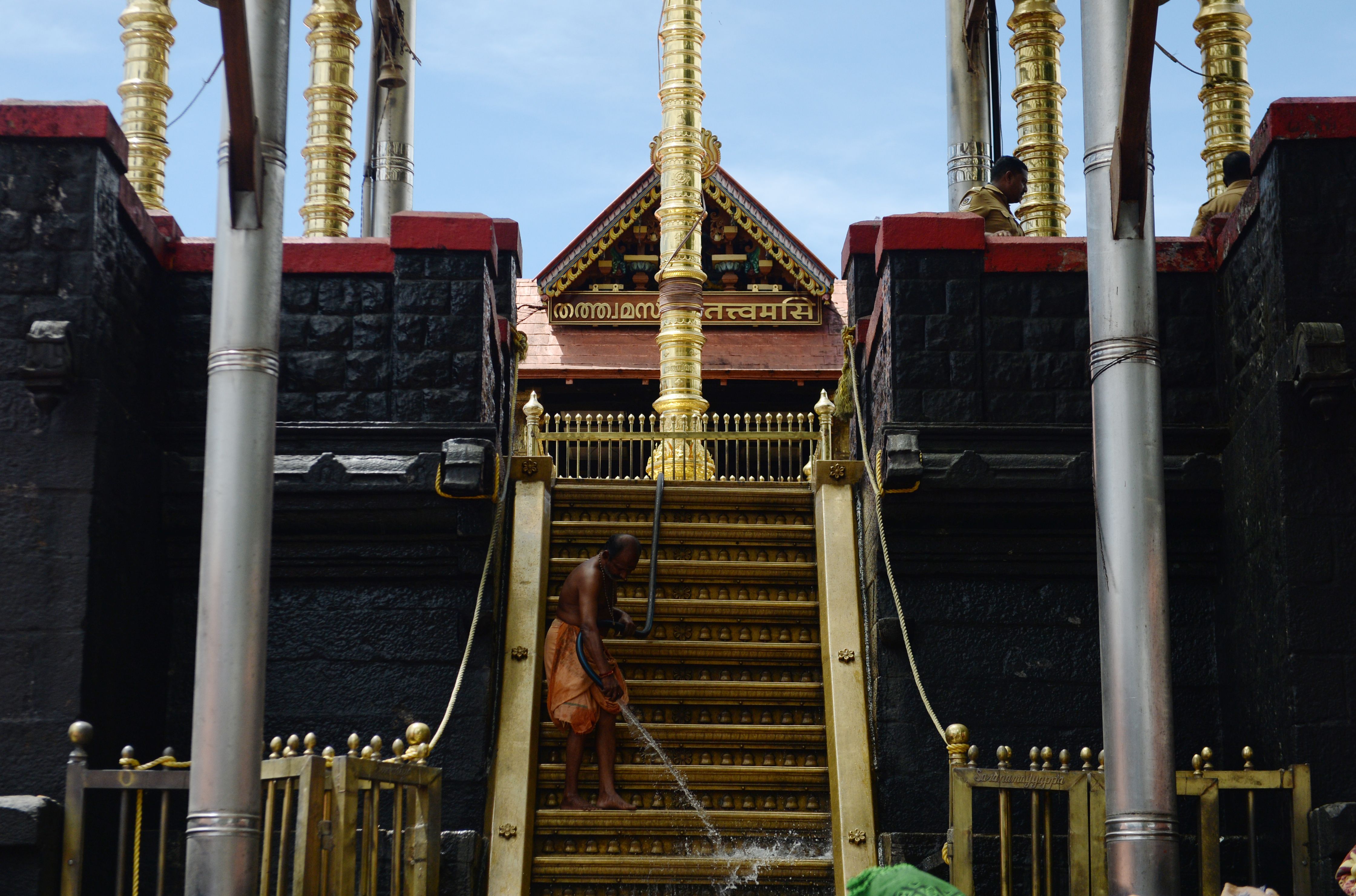 An Indian man washes the holy golden steps of Lord Ayyappa’s temple in Sabarimala, Kerala
