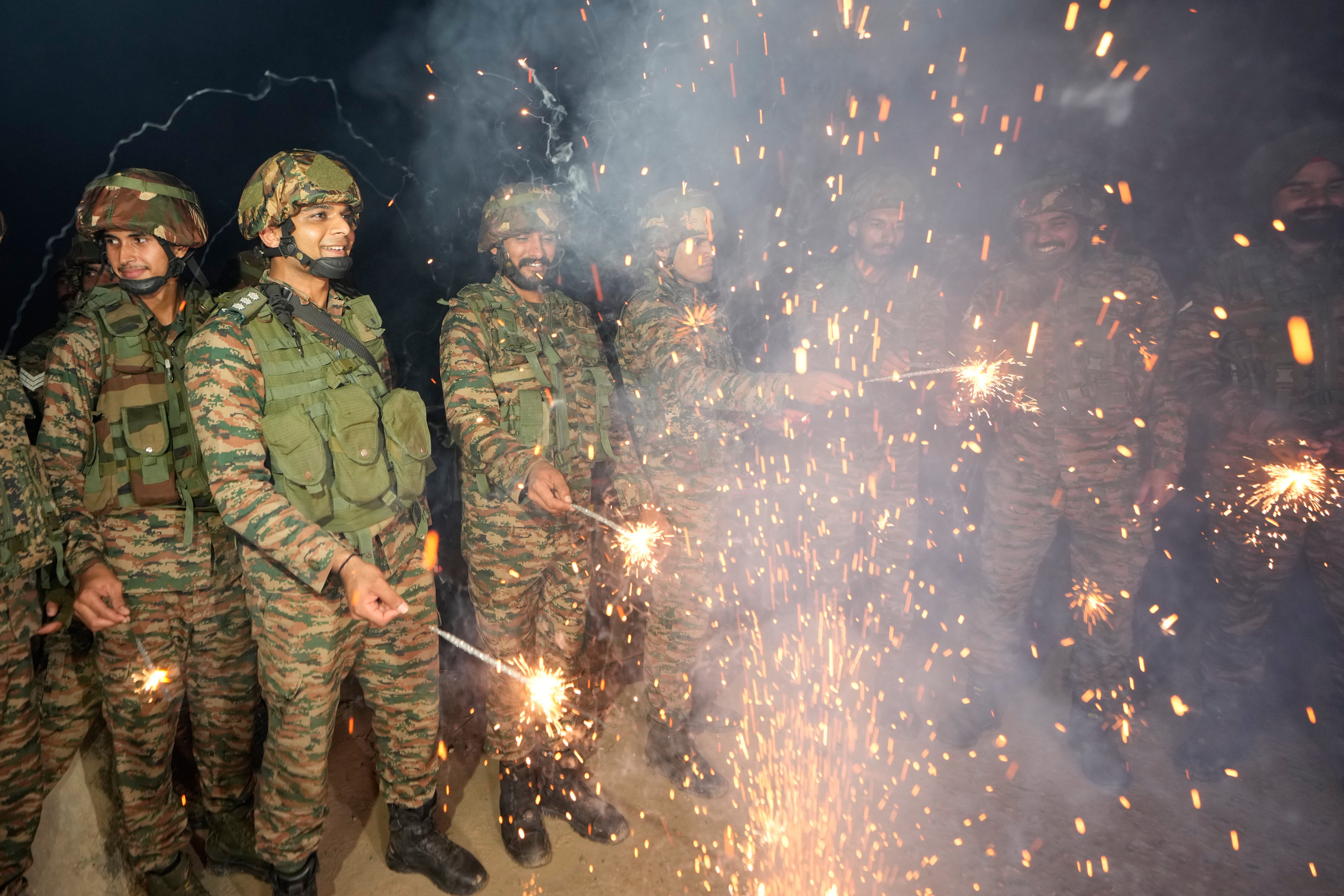 Indian army soldiers light firecrackers to celebrate Diwali, near the Line of Control that divides Kashmir region between India and Pakistan, in Akhnoor sector, Jammu and Kashmir, India.