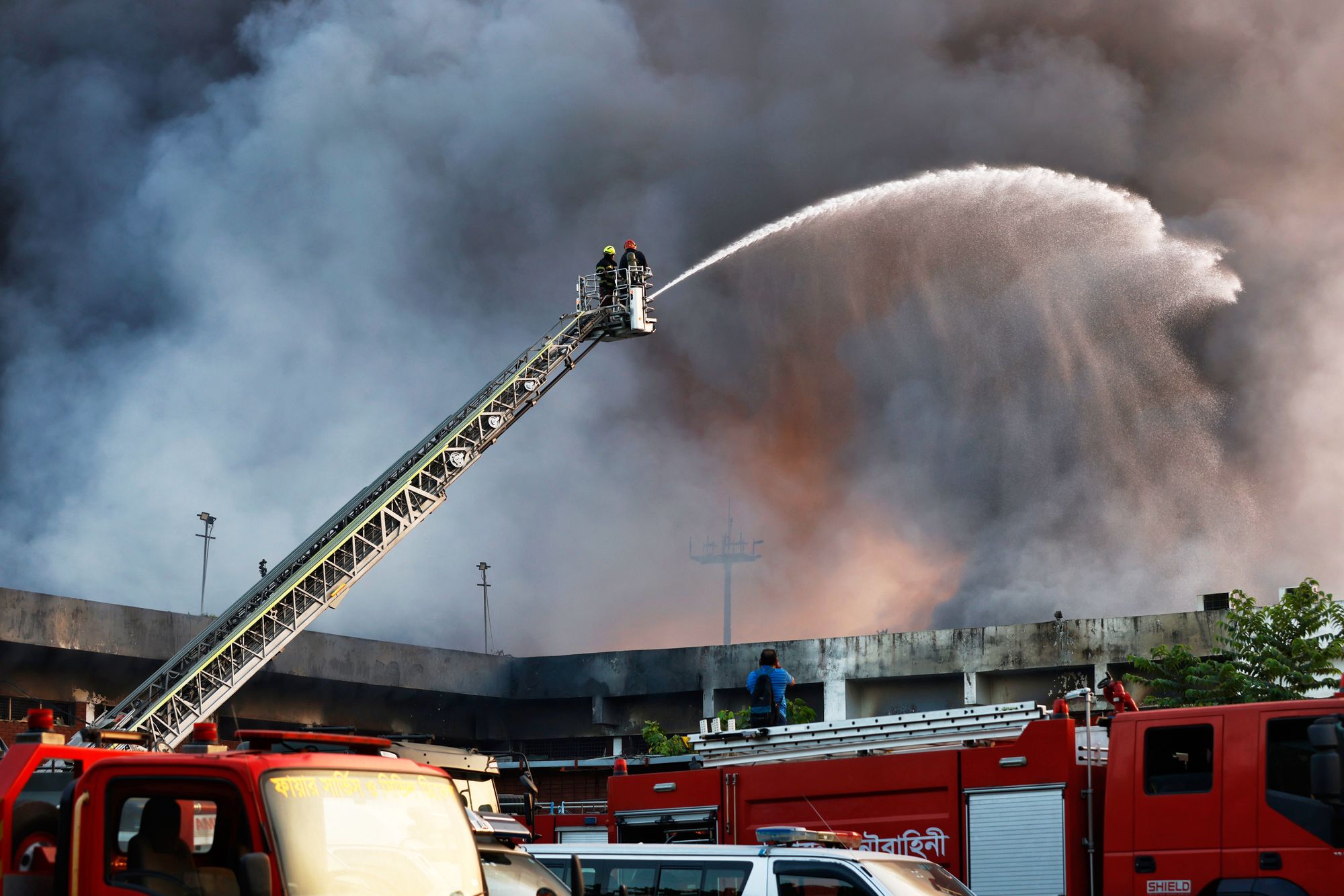 Firefighters try to contain a fire in the cargo area of Hazrat Shahjalal International Airport in Dhaka, Bangladesh, Saturday, Oct. 18, 2025. (AP Photo/Rajib Dhar)