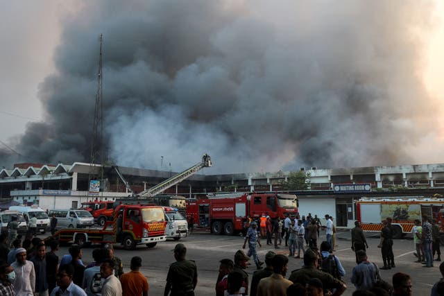 <p>Onlookers gather as firefighters try to extinguish a fire that broke out in the cargo section of Hazrat Shahjalal International Airport in Dhaka</p>
