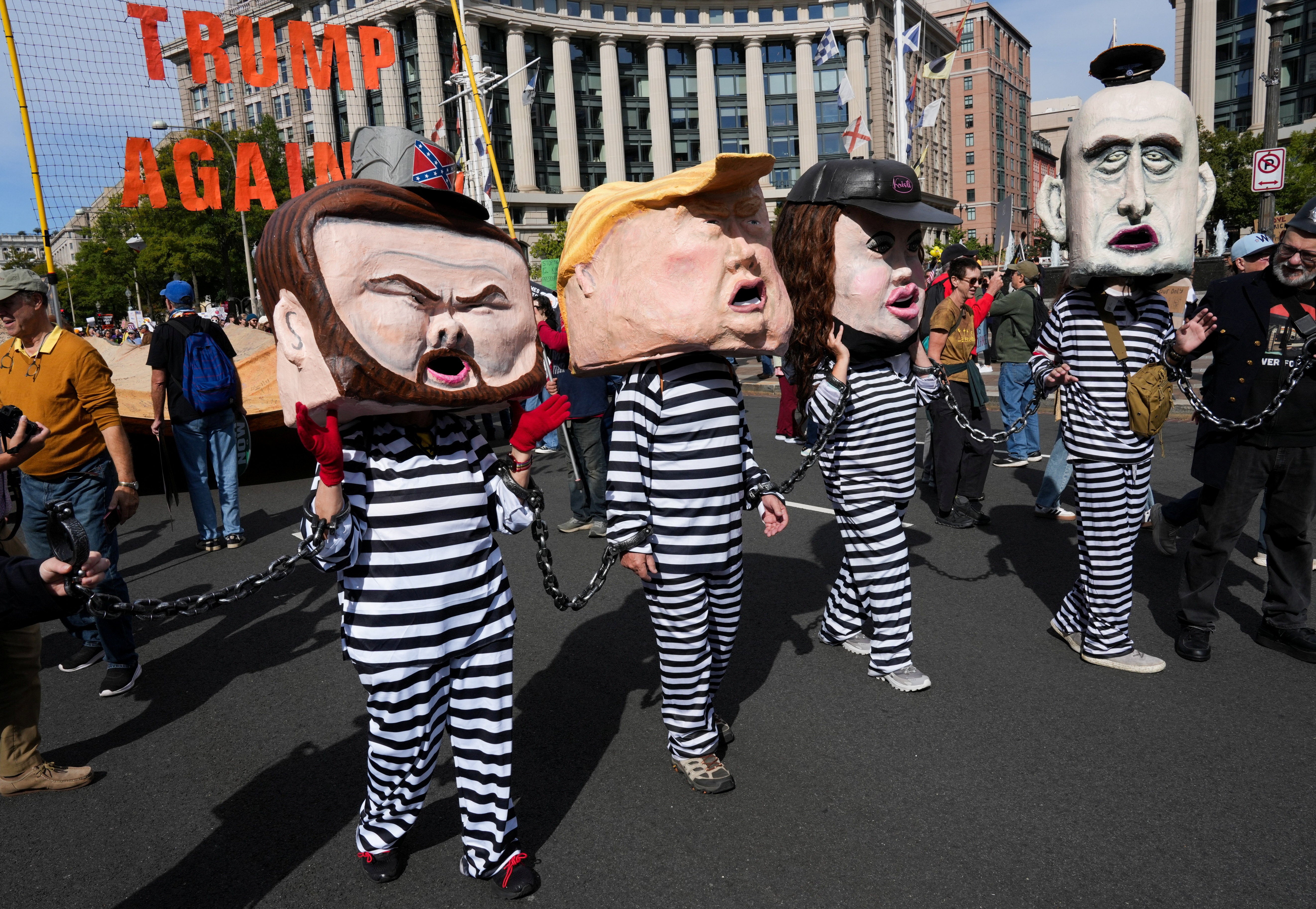 Demonstrators depicting Donald Trump, JD Vance, Kristi Noem, and Stephen Miller dressed as convicts in Washington, D.C.