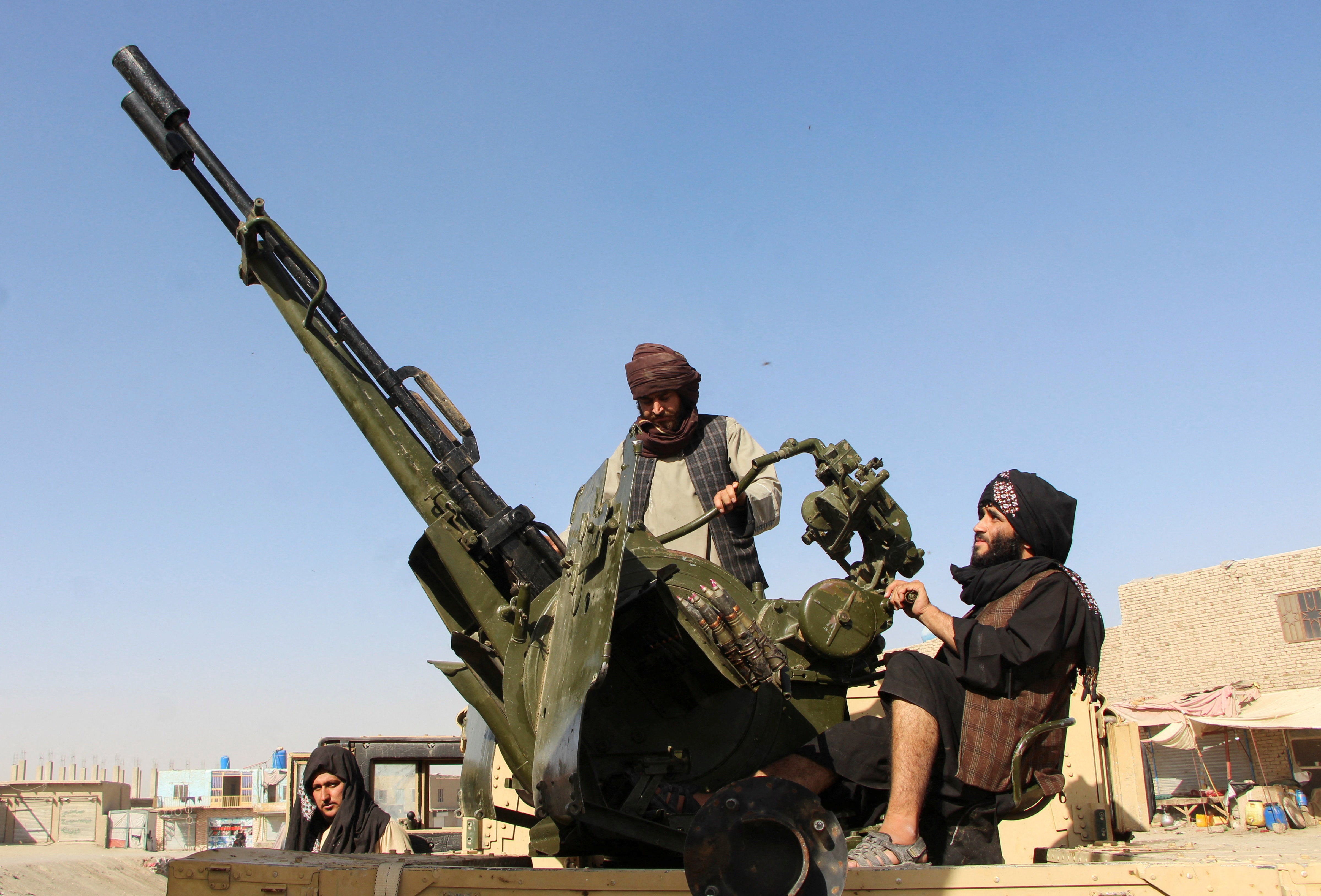 <p>An Afghan Taliban fighter sits next to an anti-aircraft gun near the border with Pakistan in Spin Boldak</p>