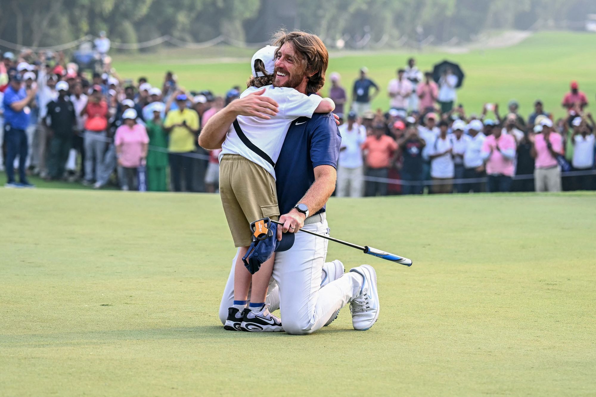 <p>Tommy Fleetwood embraced his son Frankie after securing victory in Delhi</p>