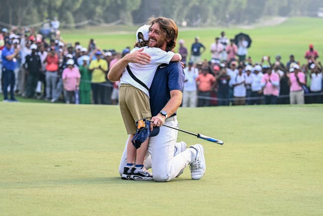 <p>Tommy Fleetwood embraced his son Frankie after securing victory in Delhi</p>