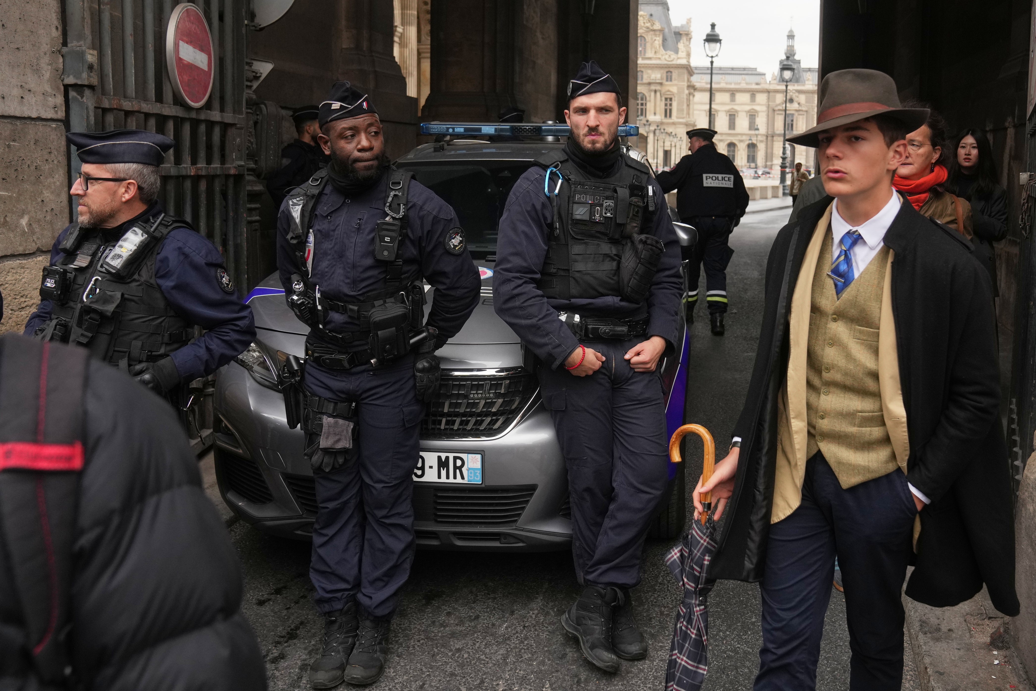 Police officers block access to the Louvre after the robbery