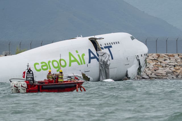 <p>Rescue workers approach a cargo aircraft that skidded off a Hong Kong runway on Monday 20 October 2025</p>