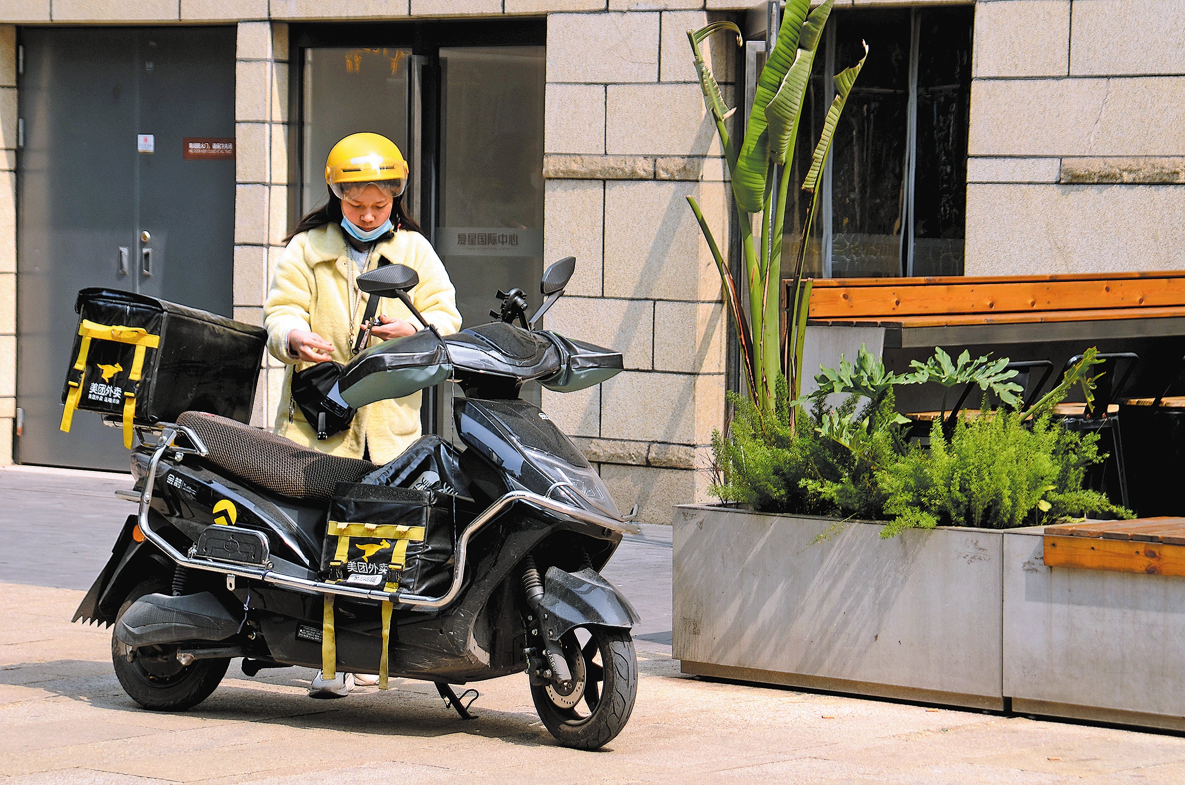 A female courier delivers food in Chongqing in March 2023