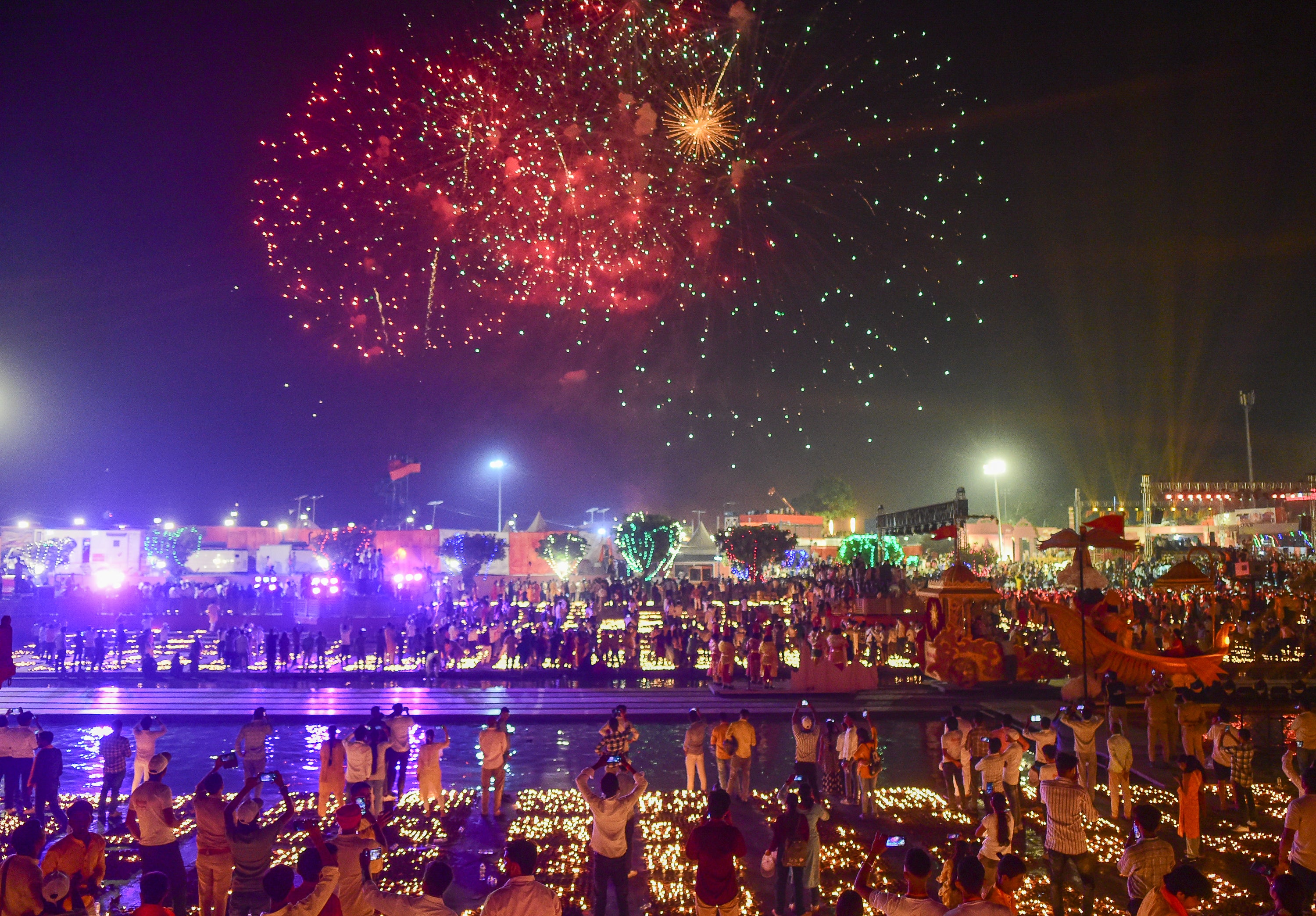Locals watch a firework show on the banks of the Saryu River on 19 October, the eve of Diwali festival, in Ayodhya, northern India