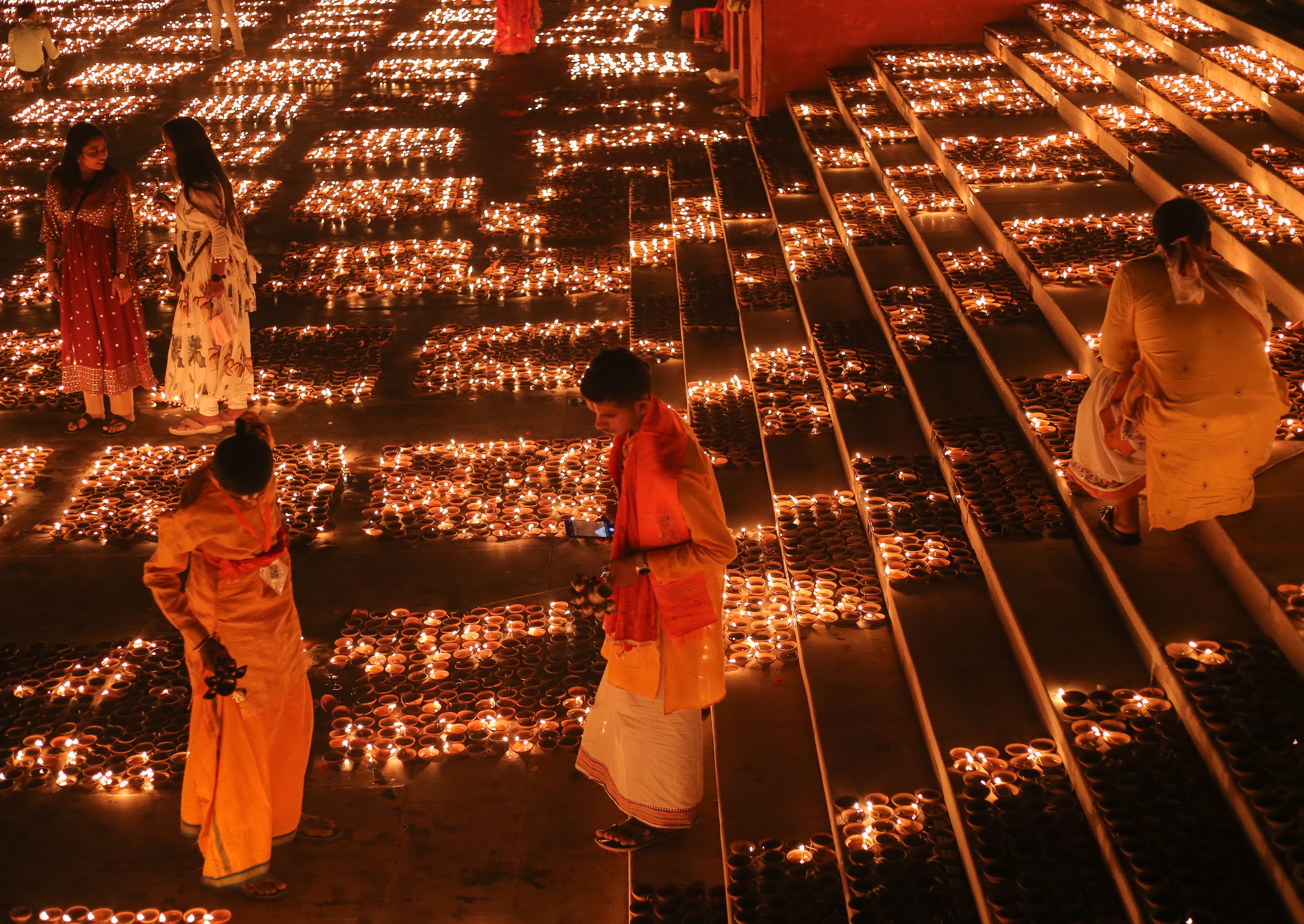 People light up earthen lamps on the banks of the Saryu