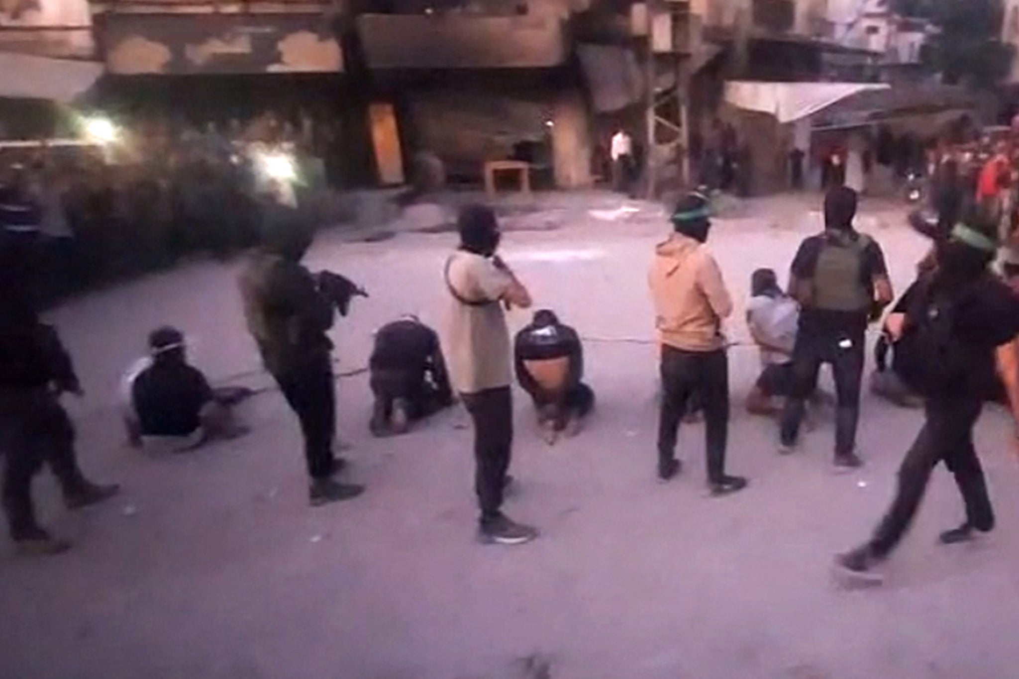 This image grab from a video released by the Hamas-run Al-Aqsa TV's Telegram channel on 13 October 2025, shows armed Hamas fighters standing behind blindfolded, bound and kneeling men in Gaza City
