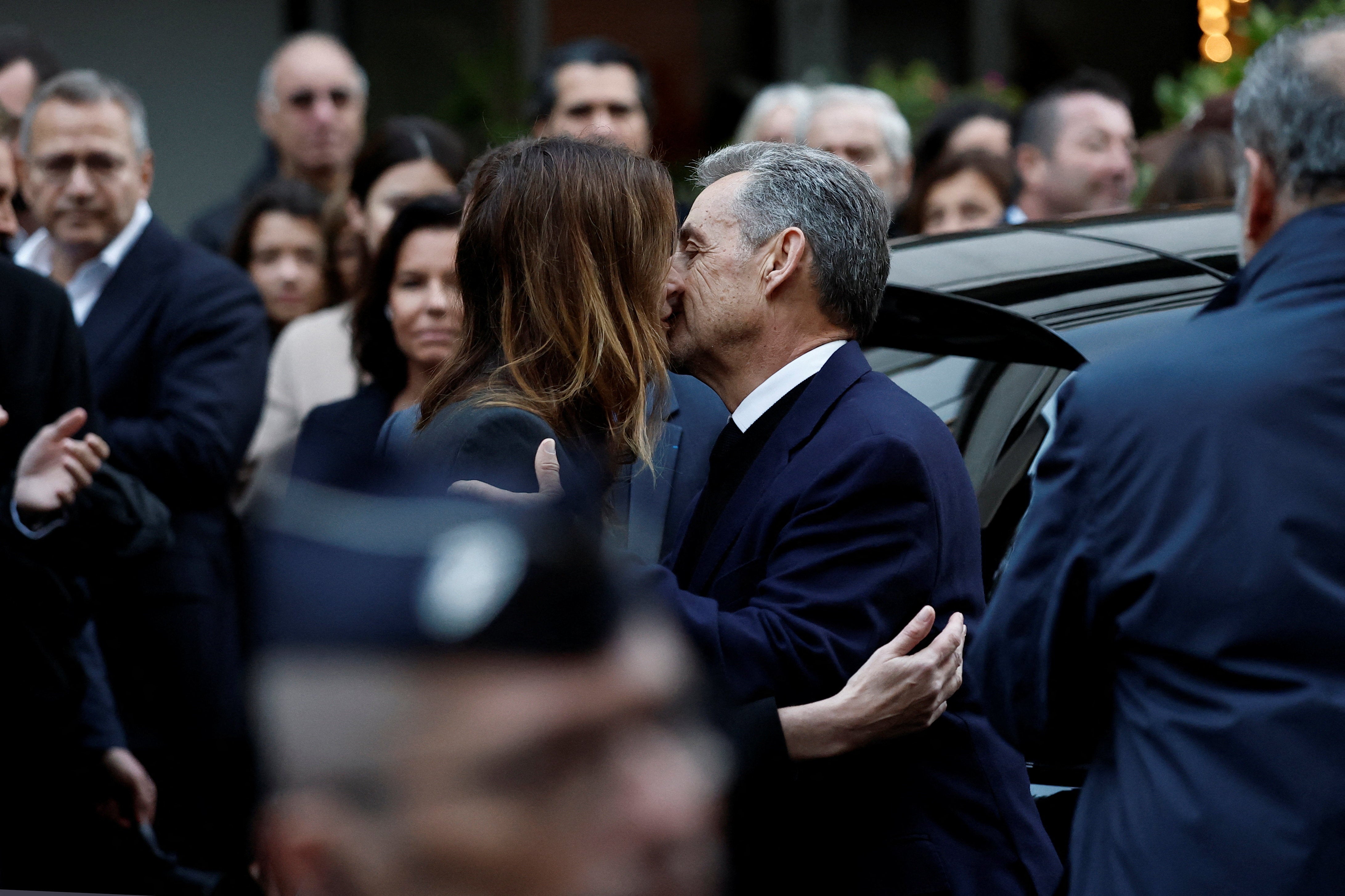 Sarkozy kisses his wife Carla Bruni-Sarkozy before leaving in a car on the day of his incarceration