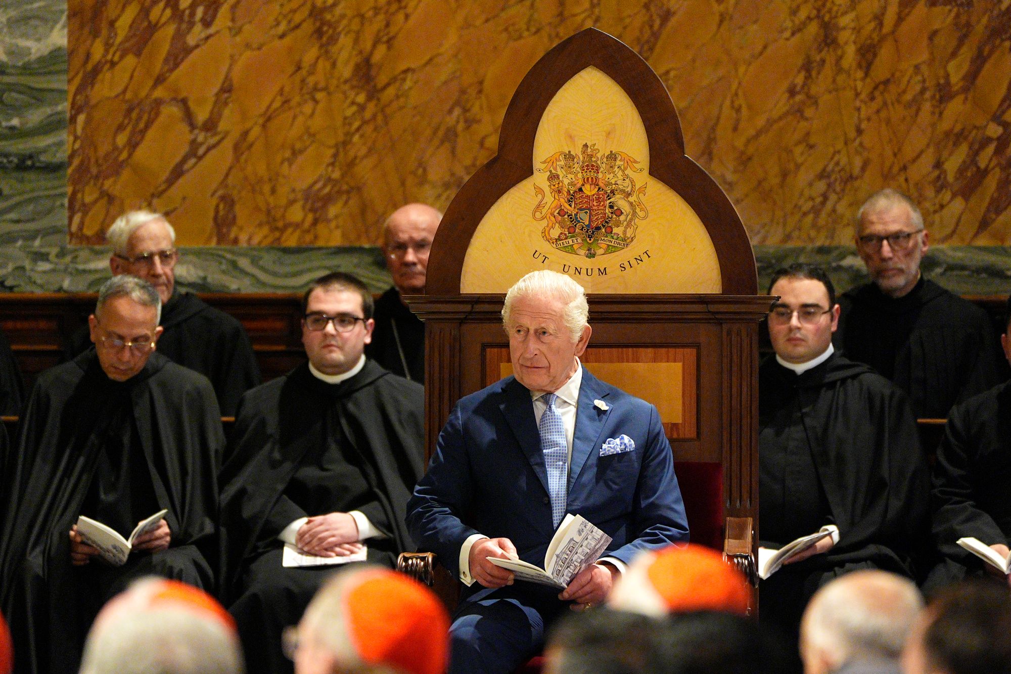 King Charles sits in a specially created seat displaying his Coat of Arms, which was given as a gift in honour of becoming Royal Confrater of the Abbey, during his visit to the Papal Basilica and Abbey of St Paul's Outside the Walls in Rome