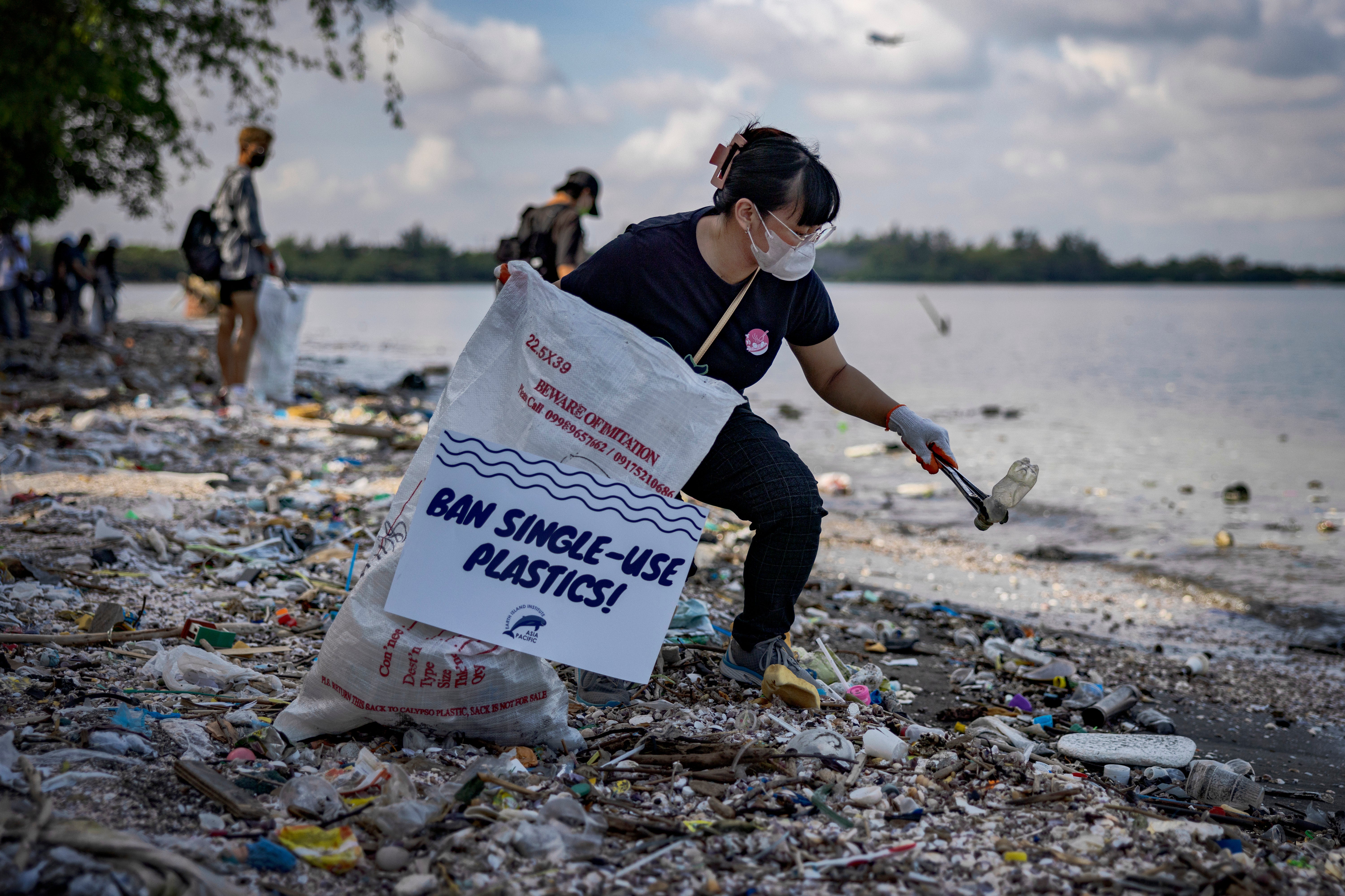 A volunteer collects plastic waste on a beach in the Philippines in September 2023. Plastic pollution is everywhere, with more than 170 trillion pieces in oceans around the world