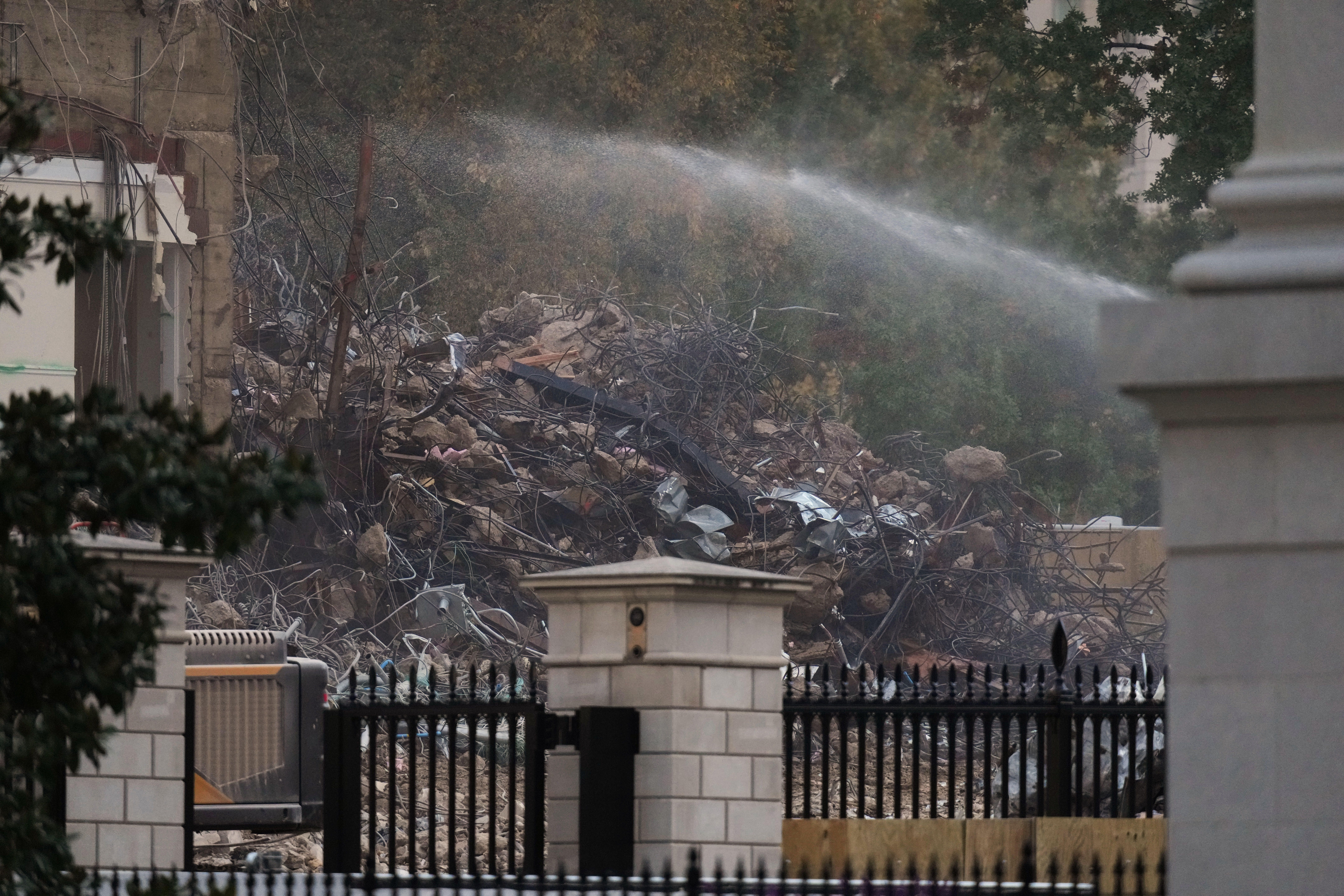 Piles of debris, created from the destruction of the building, were sprayed with water on the White House lawn to control dust